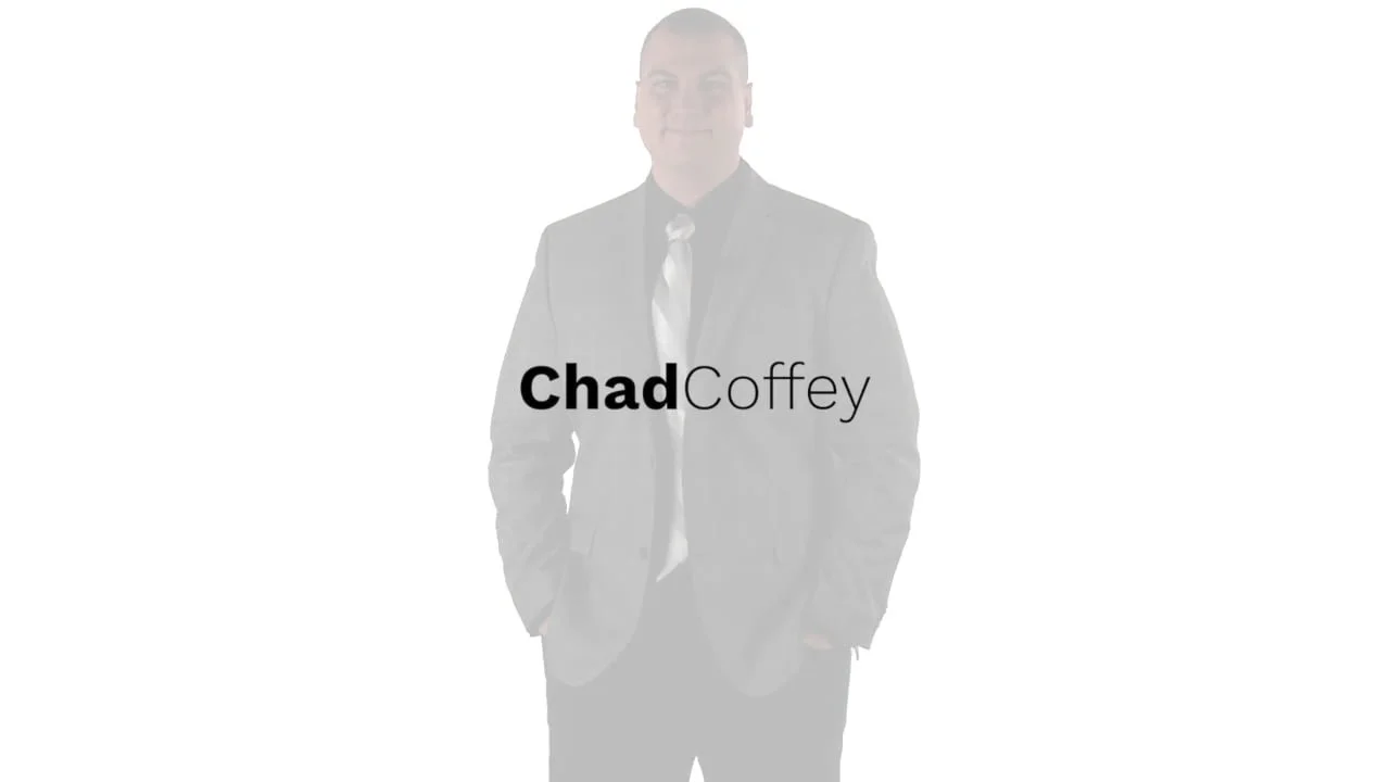 A man in a suit and tie with his hands in his pockets, standing against a plain background. The text 'Chad Coffey' is overlaid on the image.