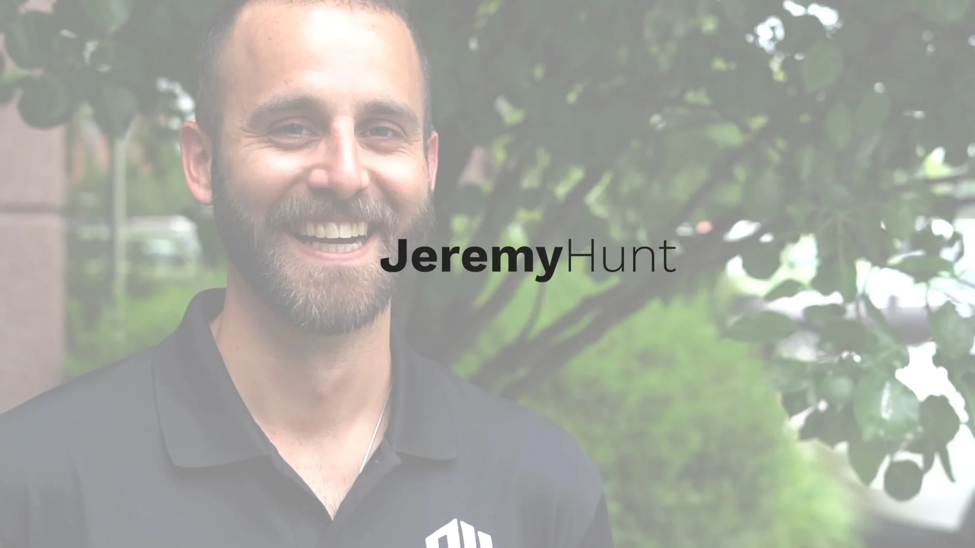 A smiling man with a beard and mustache is outside, with green trees and blurry cars in the background. The text "Jeremy Hunt" is overlaid across the middle of the image.