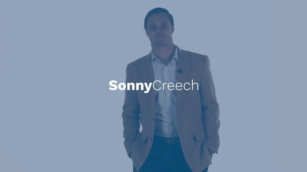 A man in a suit stands with his hands in his pockets, with text overlayed that reads "Sonny Creech".