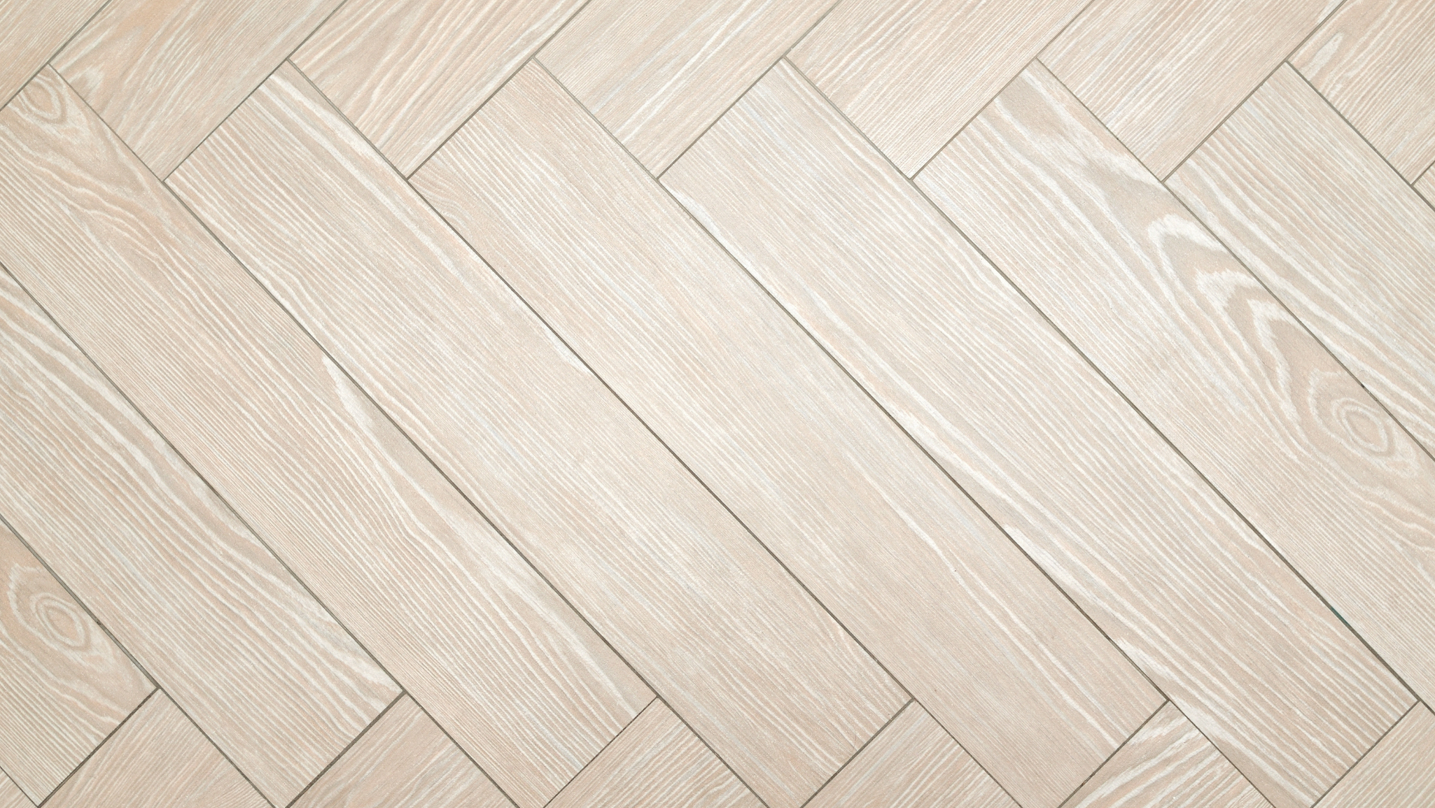 Light wood parquet flooring arranged in a herringbone pattern