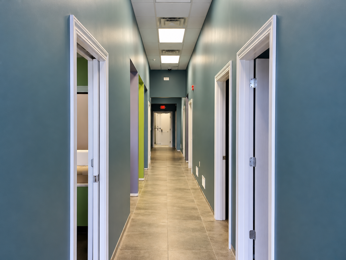Symmetrical Teal Office Hallway with Exit Sign.png