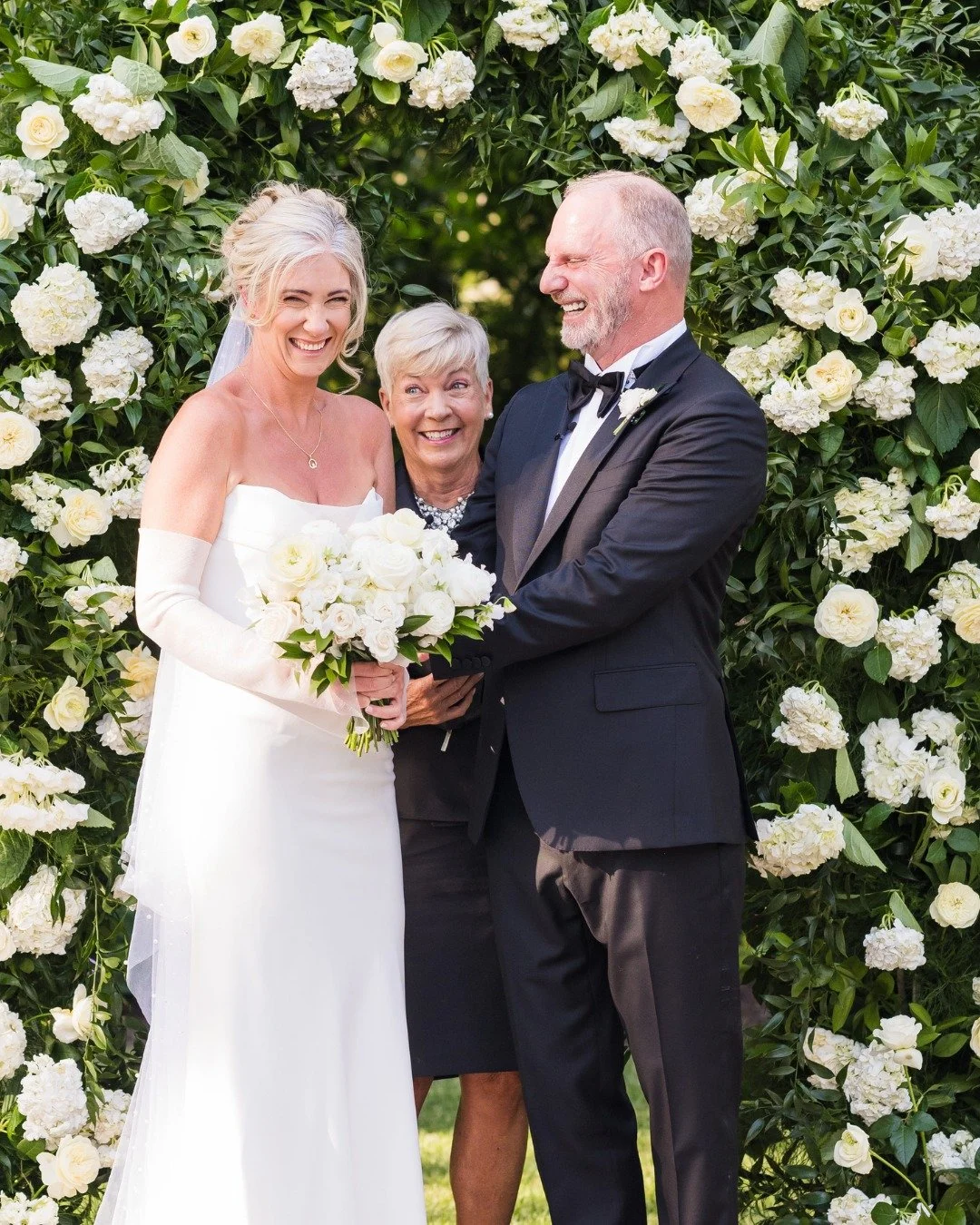 When I think about this ceremony, I don&rsquo;t just see a beautiful floral arch. I see a family story unfolding in real time. They said their vows surrounded by white roses as parents and grandparents leaned in from the front rows, and there were ju