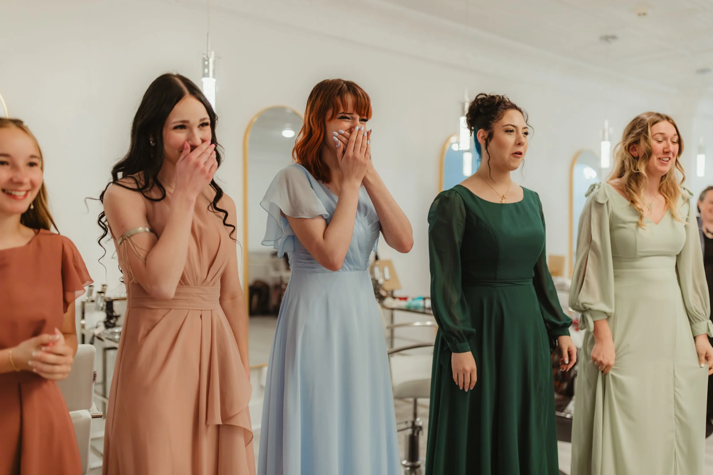 Bridesmaids in dresses in shock as bride exits changing room in The Gallery House Bridal Suite