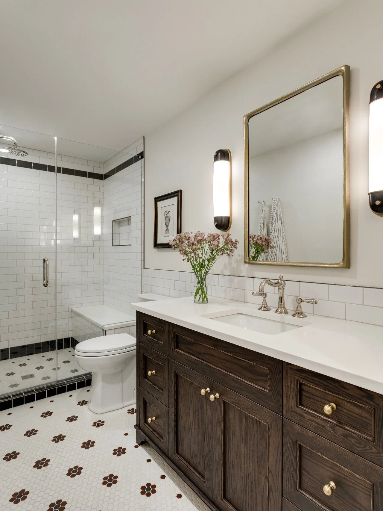 Vintage Inspiration. A nod to the glamour of the 1920s, this guest bath at #AVDHeritageHouse blends timeless details with modern luxury. From the graphic floor pattern to classic subway tile and statement lighting, every element works in harmony to c