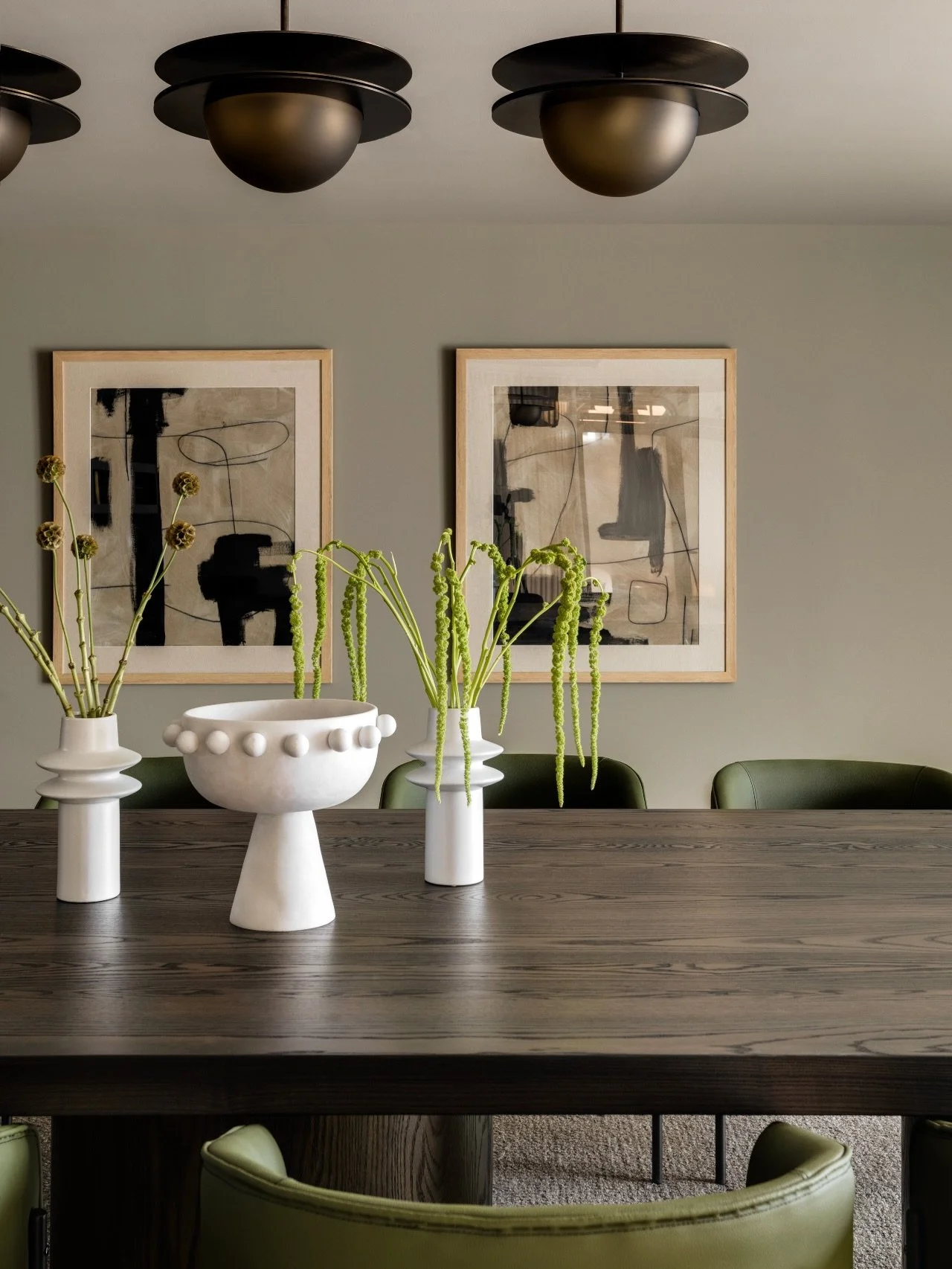 Board Room. Who says boardrooms have to be boring?

At #AVDCalgaryHouse, we designed this space to feel warm, inviting, and elevated. A custom table anchors the room, a statement light fixture adds drama, and millwork paired with green accent chairs 