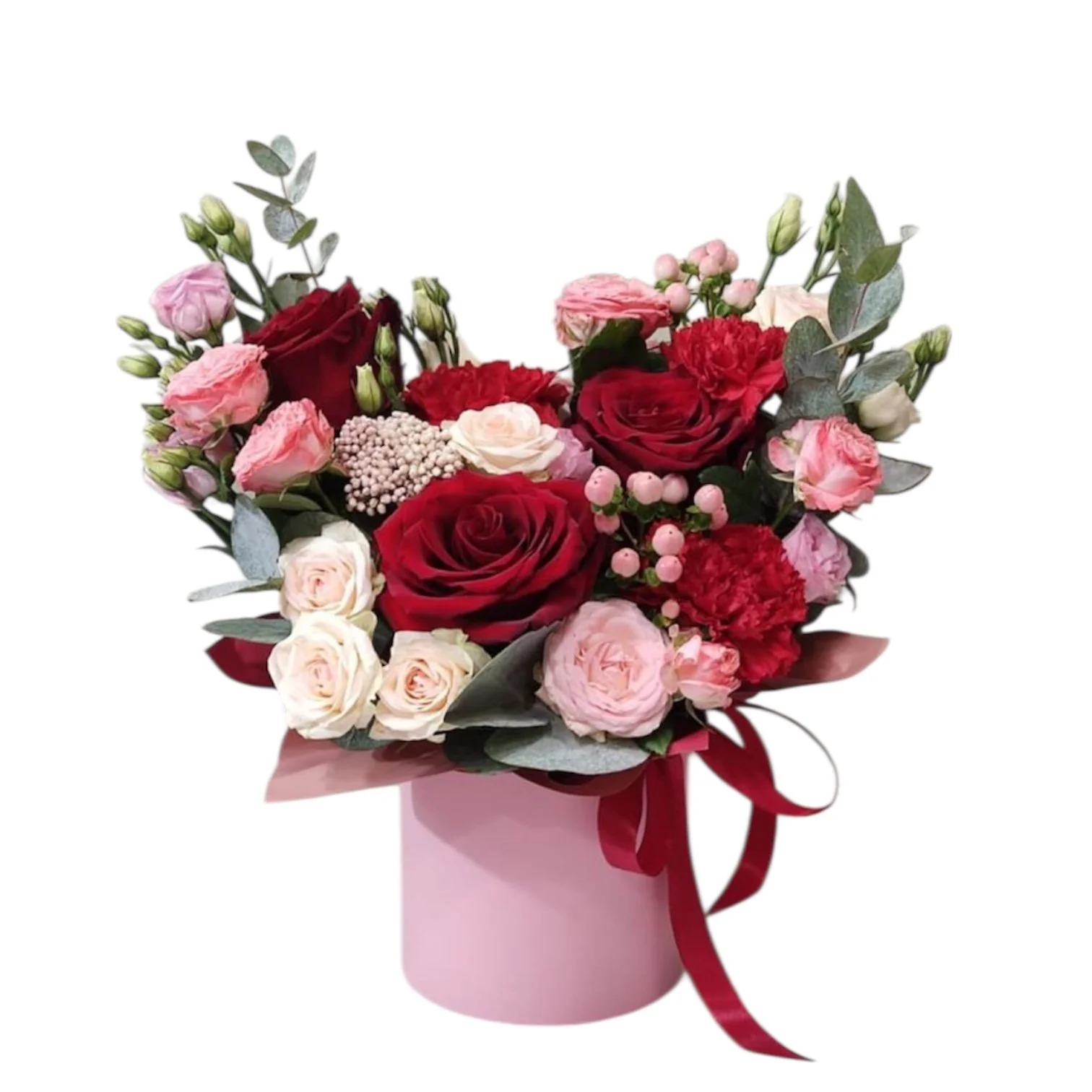 Arrangement of red, pink, and white roses and carnations in a pink hatbox with a red ribbon.