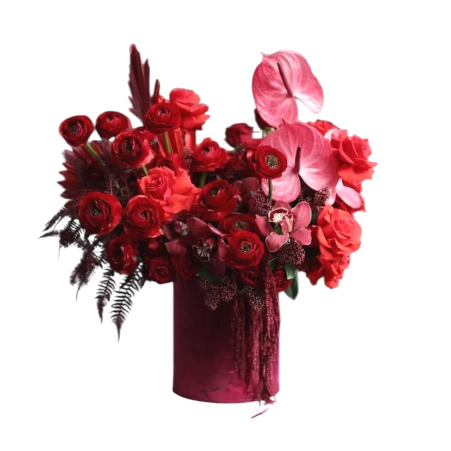 A bouquet of red flowers including roses, anthuriums, and ranunculus in a maroon vase.