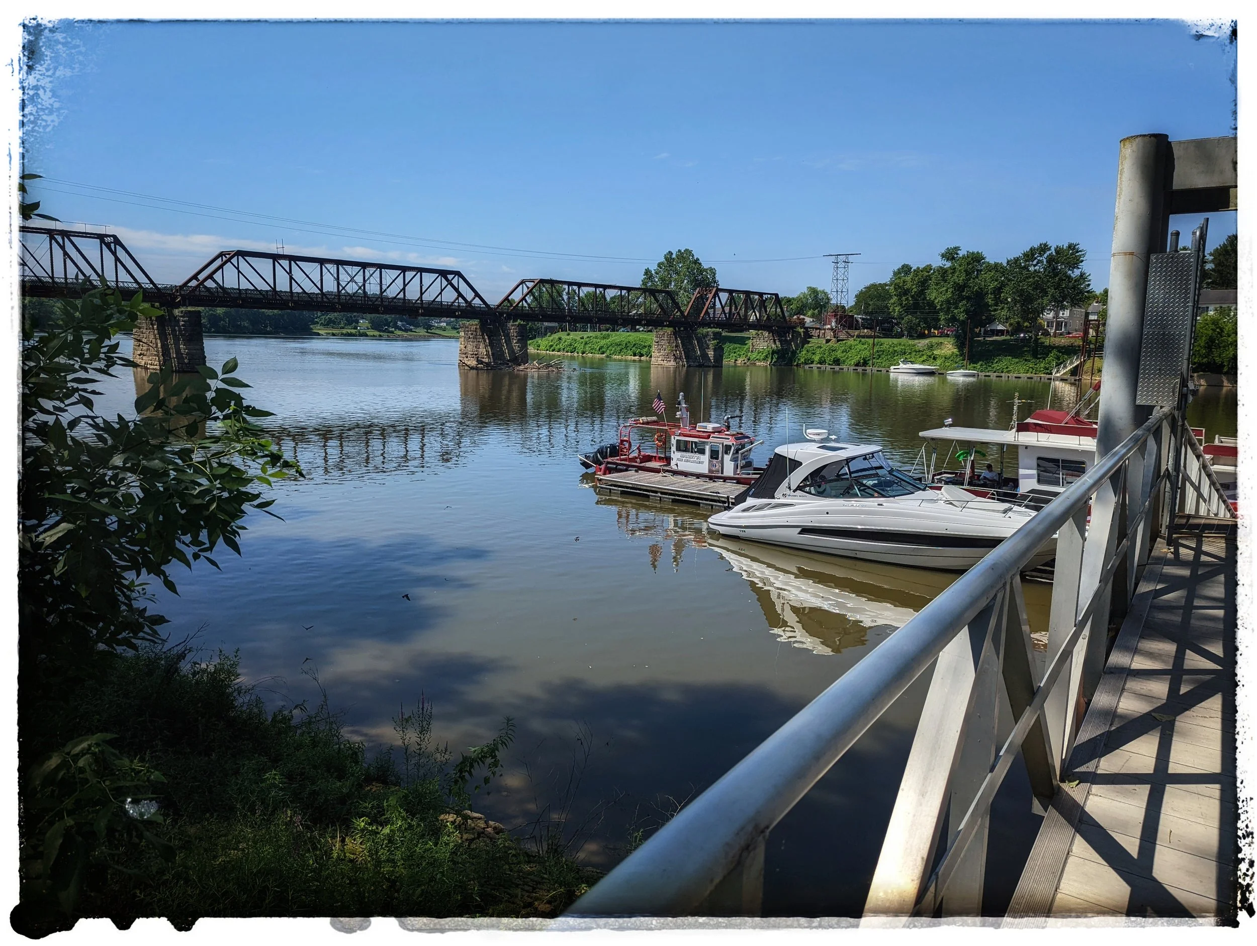 A view of boats on the Muskingum River with the historic train bridge in the background.  One of the many beautiful site in Marietta, OH.