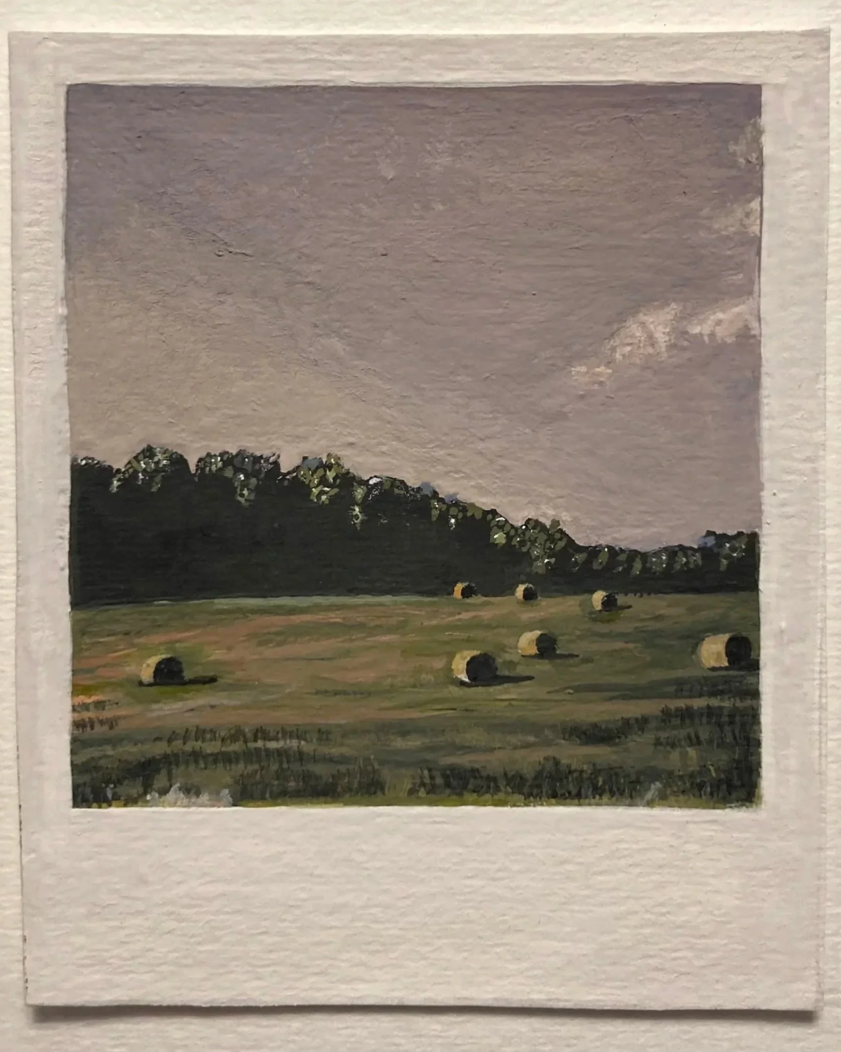 A watercolor of polaroid of a field with hay bales.