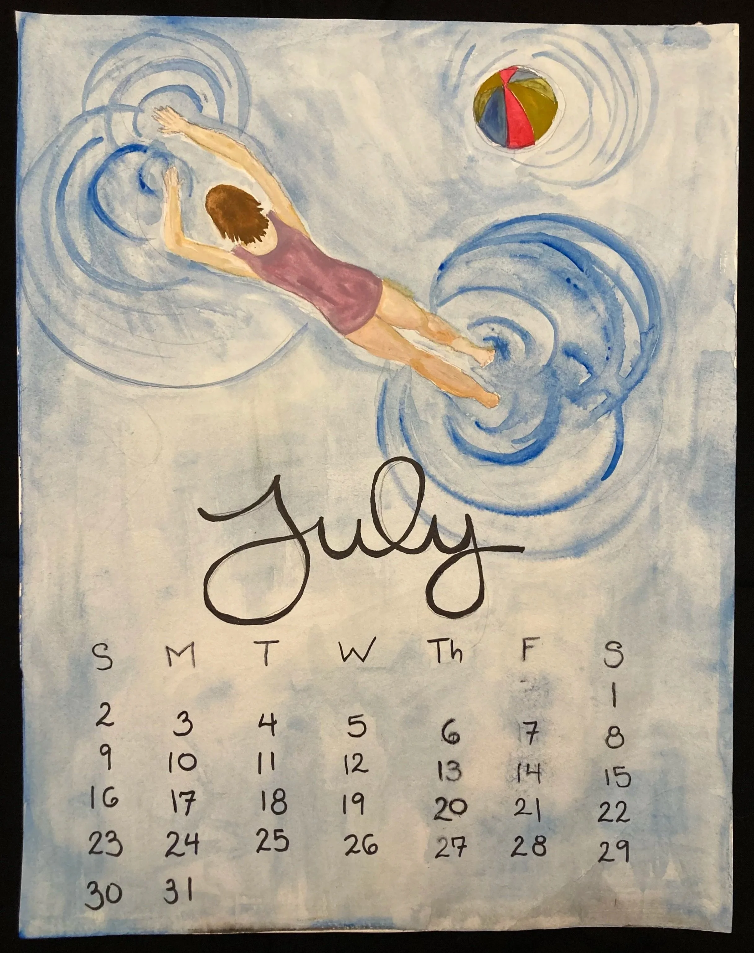 A watercolor calendar for July with a painting of a girl swimming in a pool and playing with a beach ball.