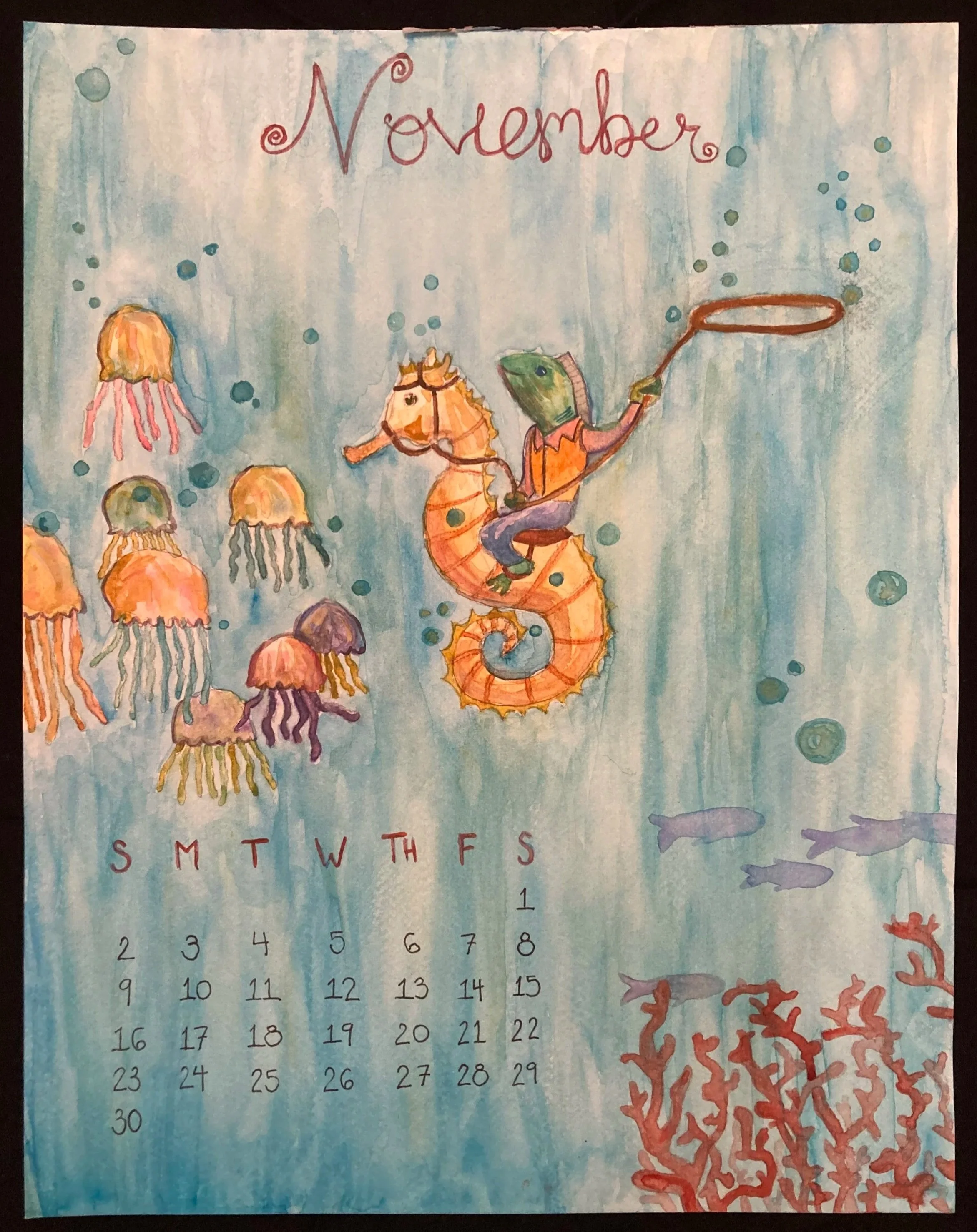 Illustrated November calendar page with an underwater scene featuring a fish riding a seahorse, jellyfish, fish, and coral.
