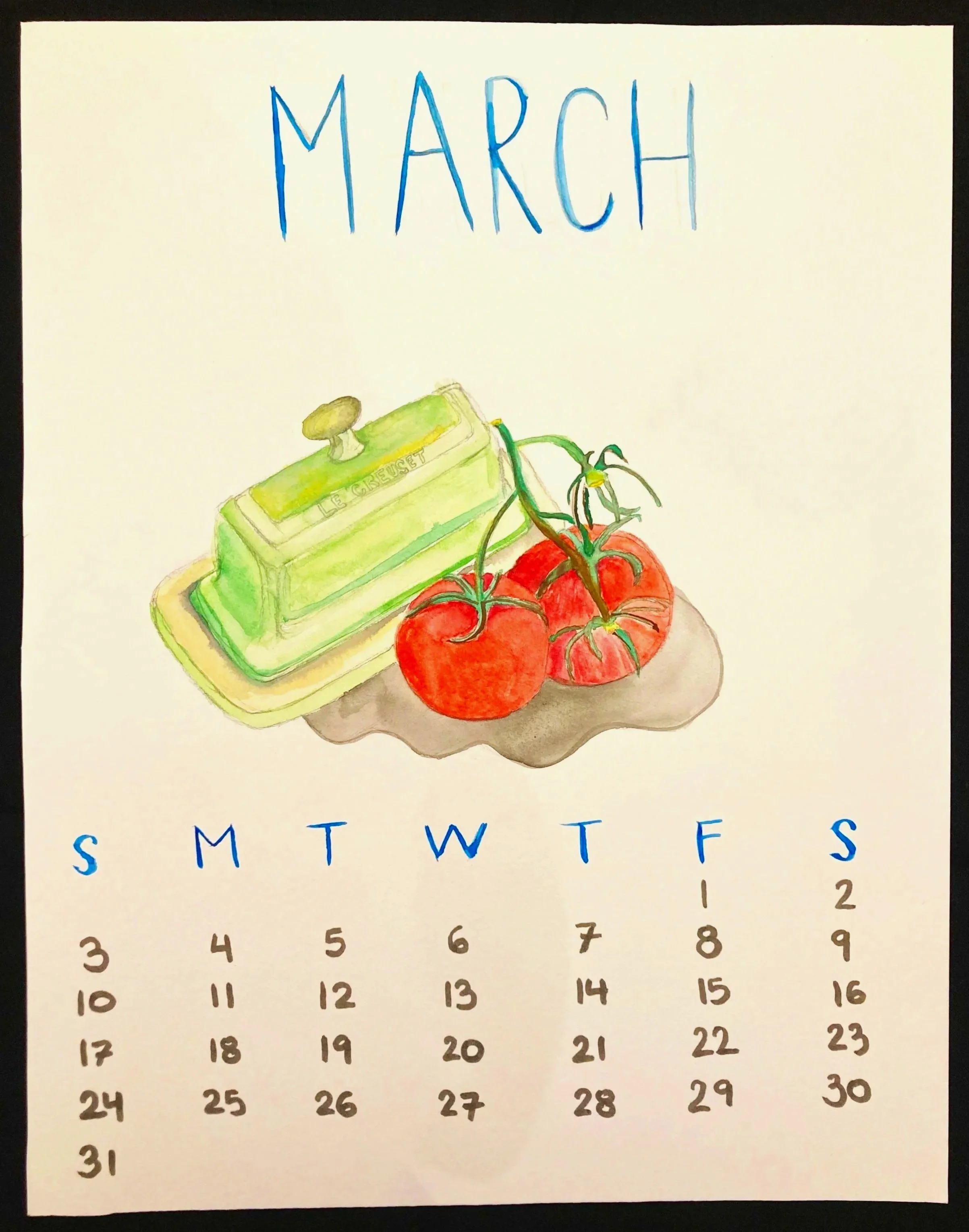 Watercolor calendar page for March with watercolor illustration of a green Le Creuset butter dish and two tomatoes.