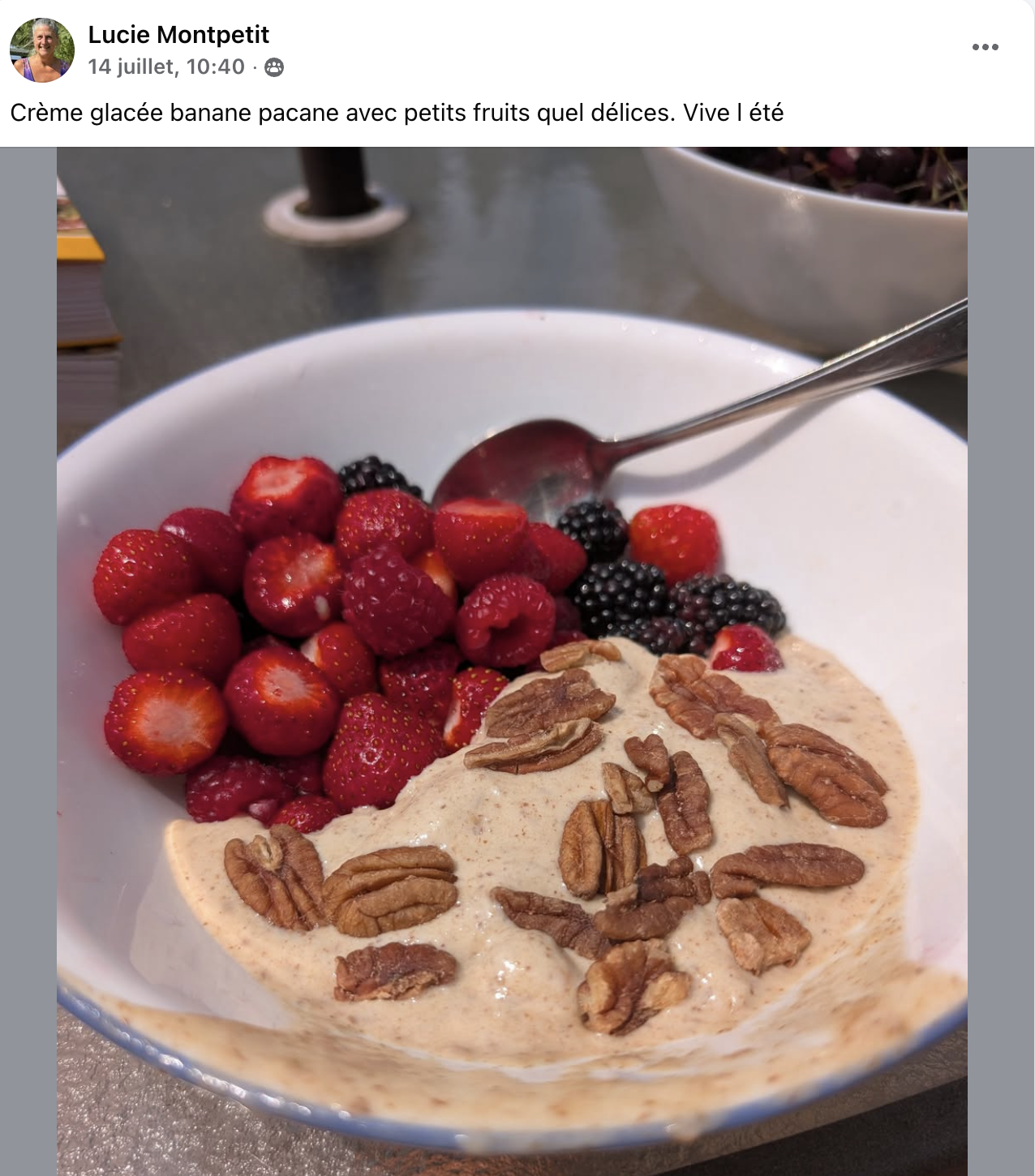 Bol de crème glacée à la banane, avec des petits fruits rouges et des noix, sur une table