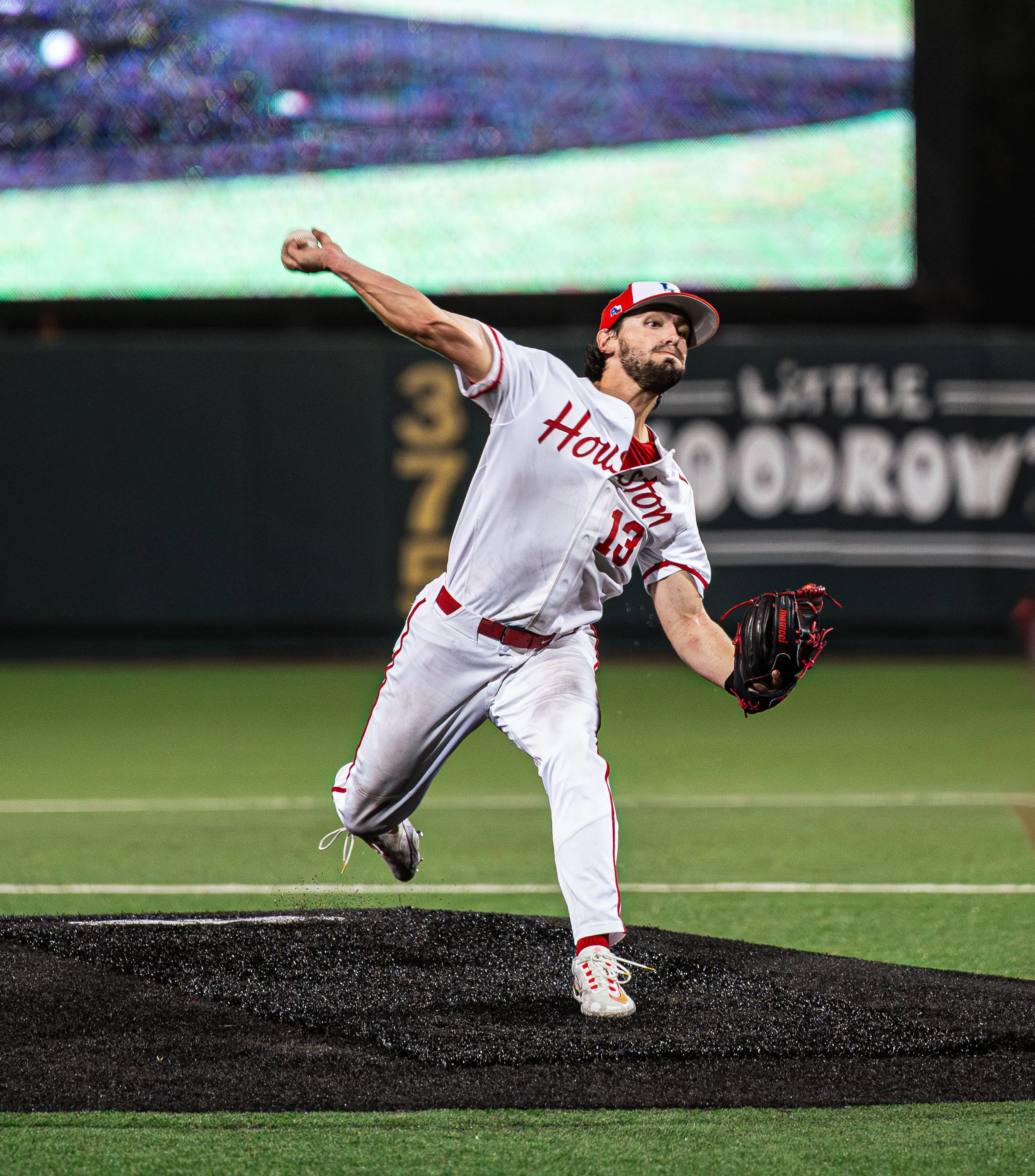 A baseball player in a Houston Astros uniform pitching on the mound.