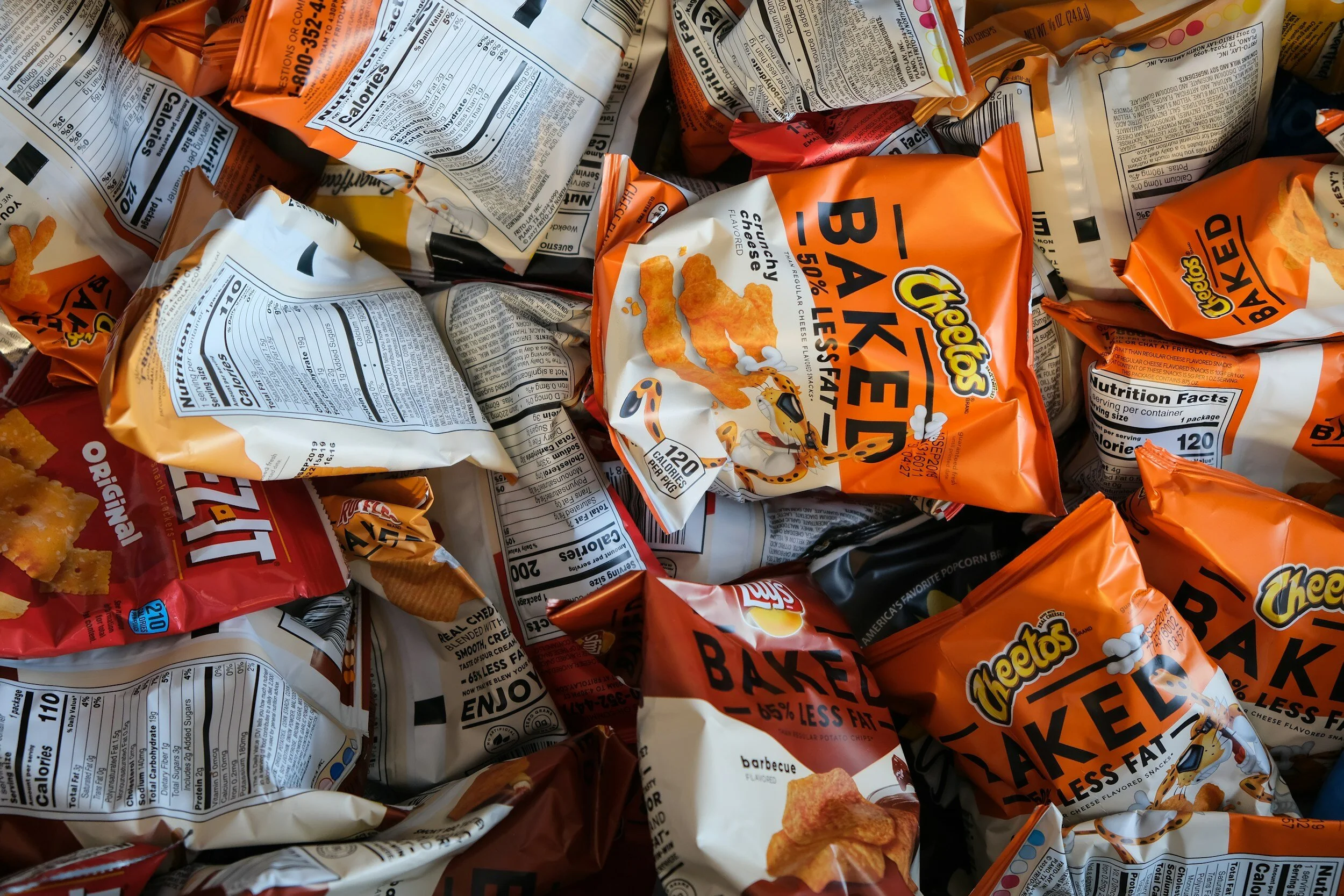 Assorted snack bags including Cheetos Baked and Cheez-It Original.