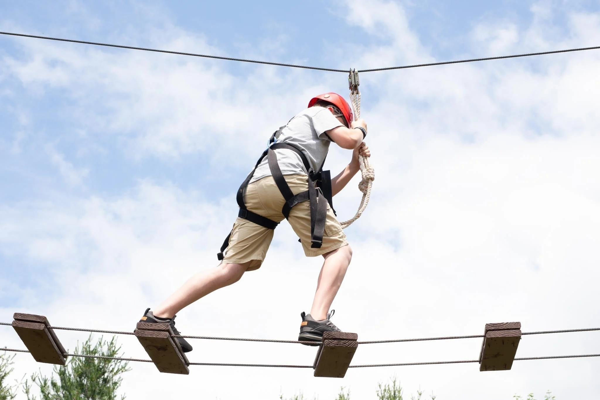 Person on ropes course with harness and helmet