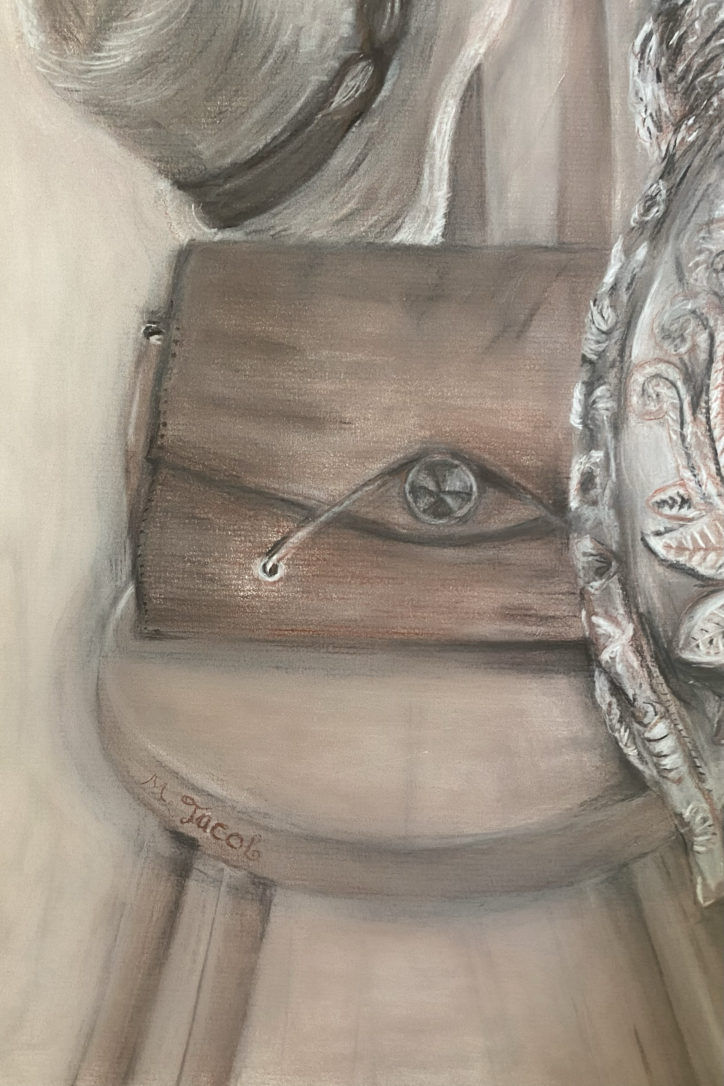 Painting of a wooden box with a handle, a round metal latch, next to a patterned fabric and a rounded object, with the signature 'M. Jacob' in the bottom left corner.