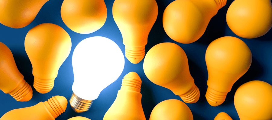 Lot of yellow light bulbs with one lit up on blue background for the Yes! FAQ Sheet for architects