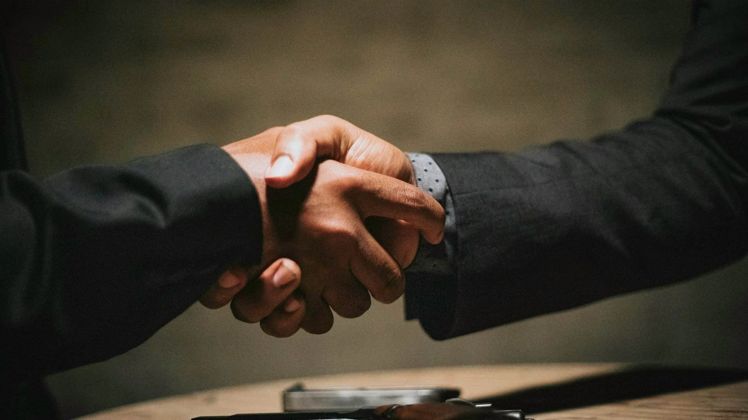 Close-up of two people in business attire shaking hands, symbolizing partnership based on the four value propositions for architects.