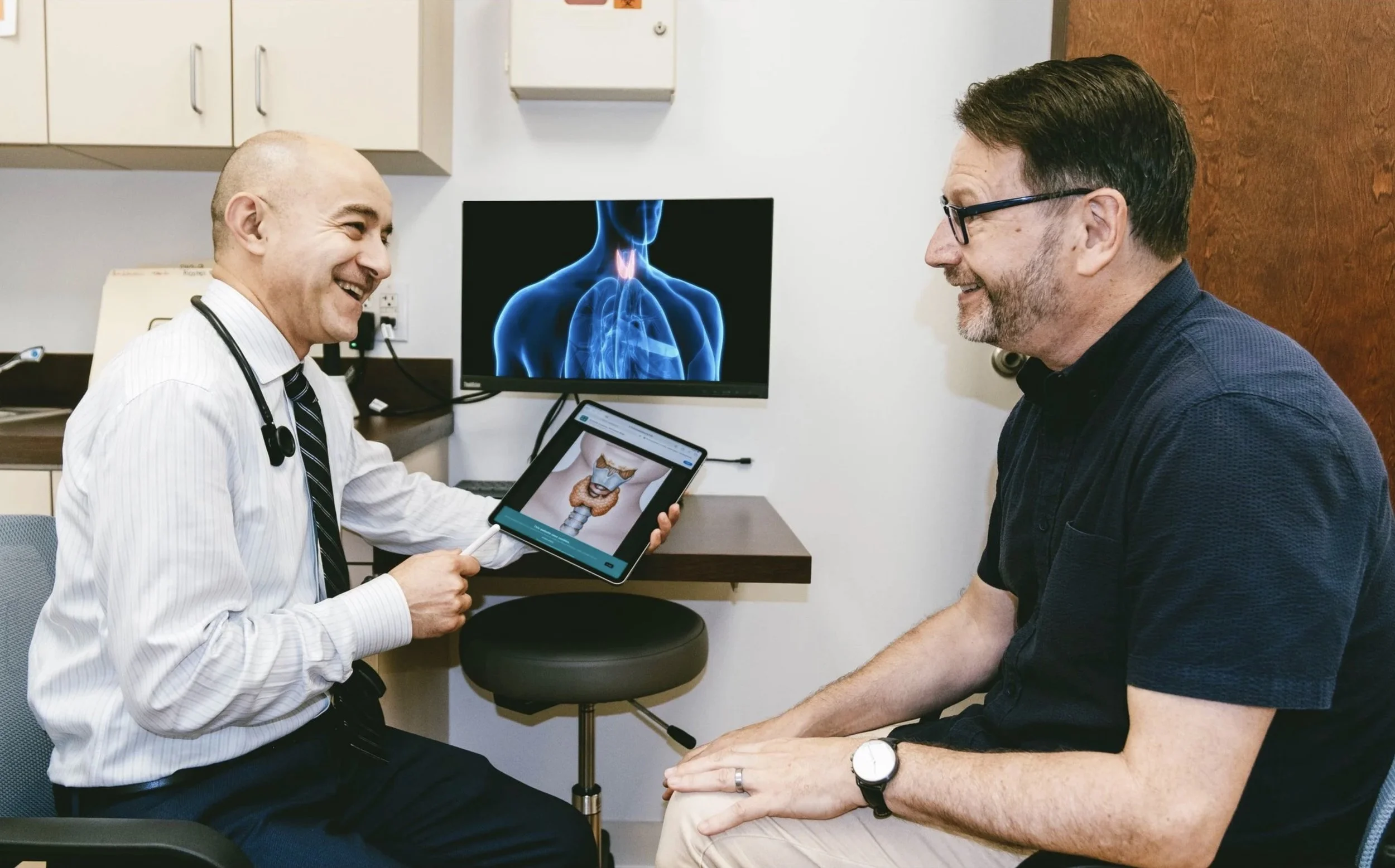 Dr. Farhad Hasan discussing thyroid anatomy with a patient at Chia Endocrinology in Wexford