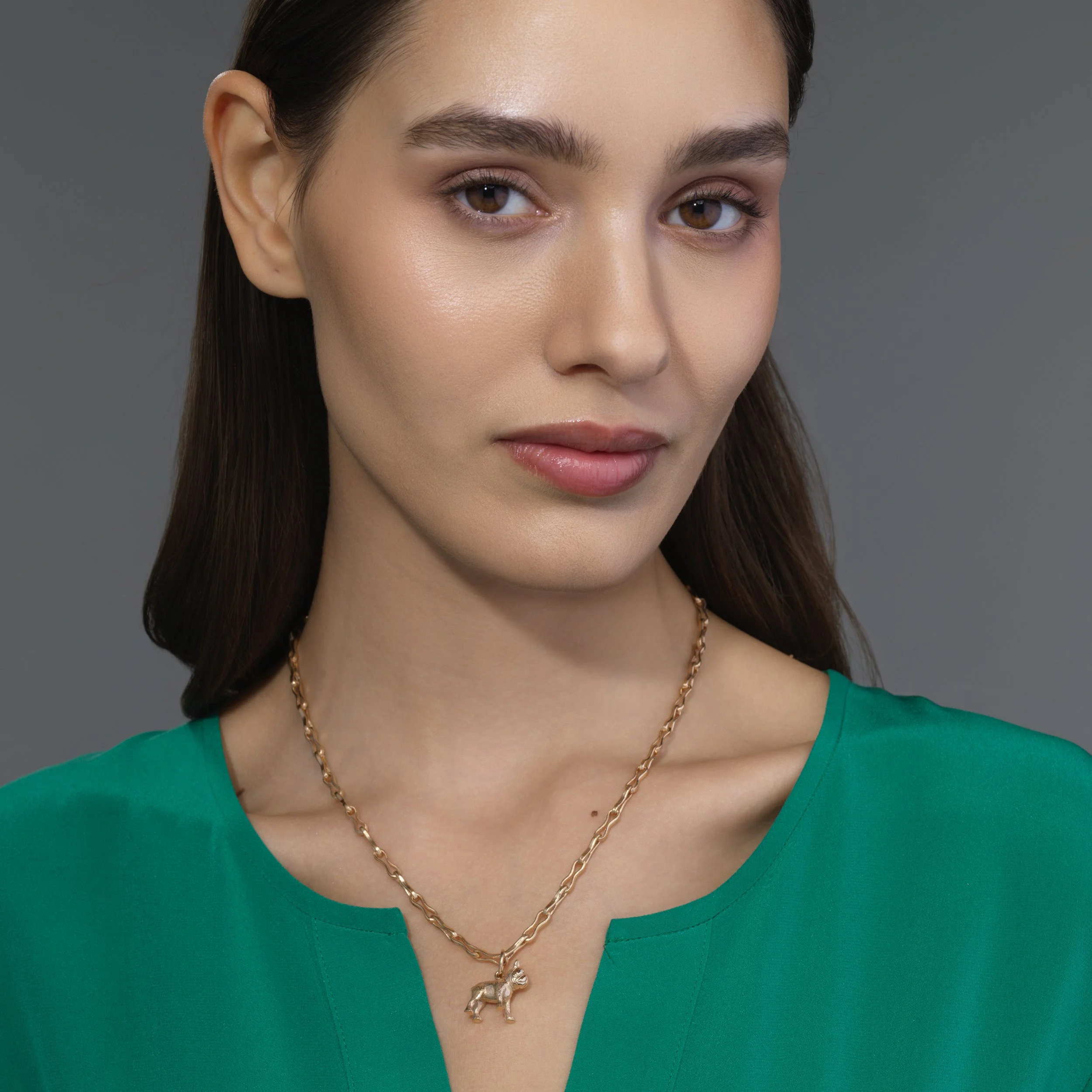 French Bulldog gold pendant shown on a model for scale