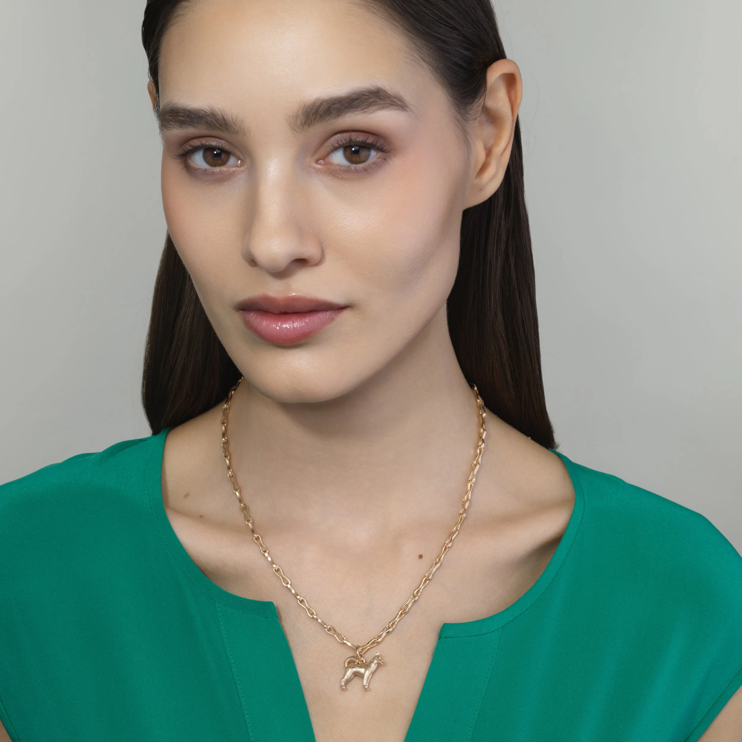 Siberian Husky gold pendant shown on a model for scale