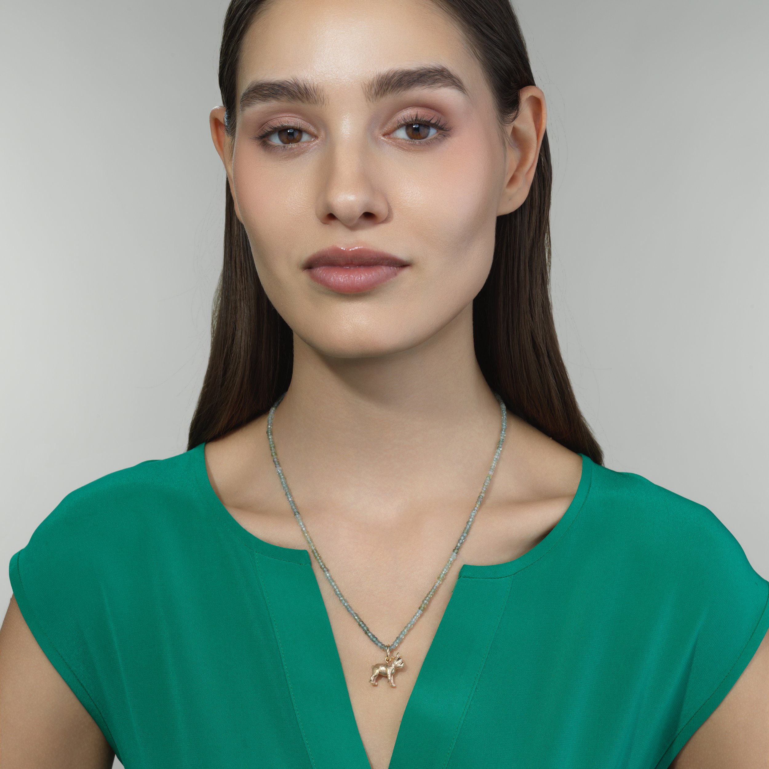 French Bulldog gold pendant shown on a model for scale