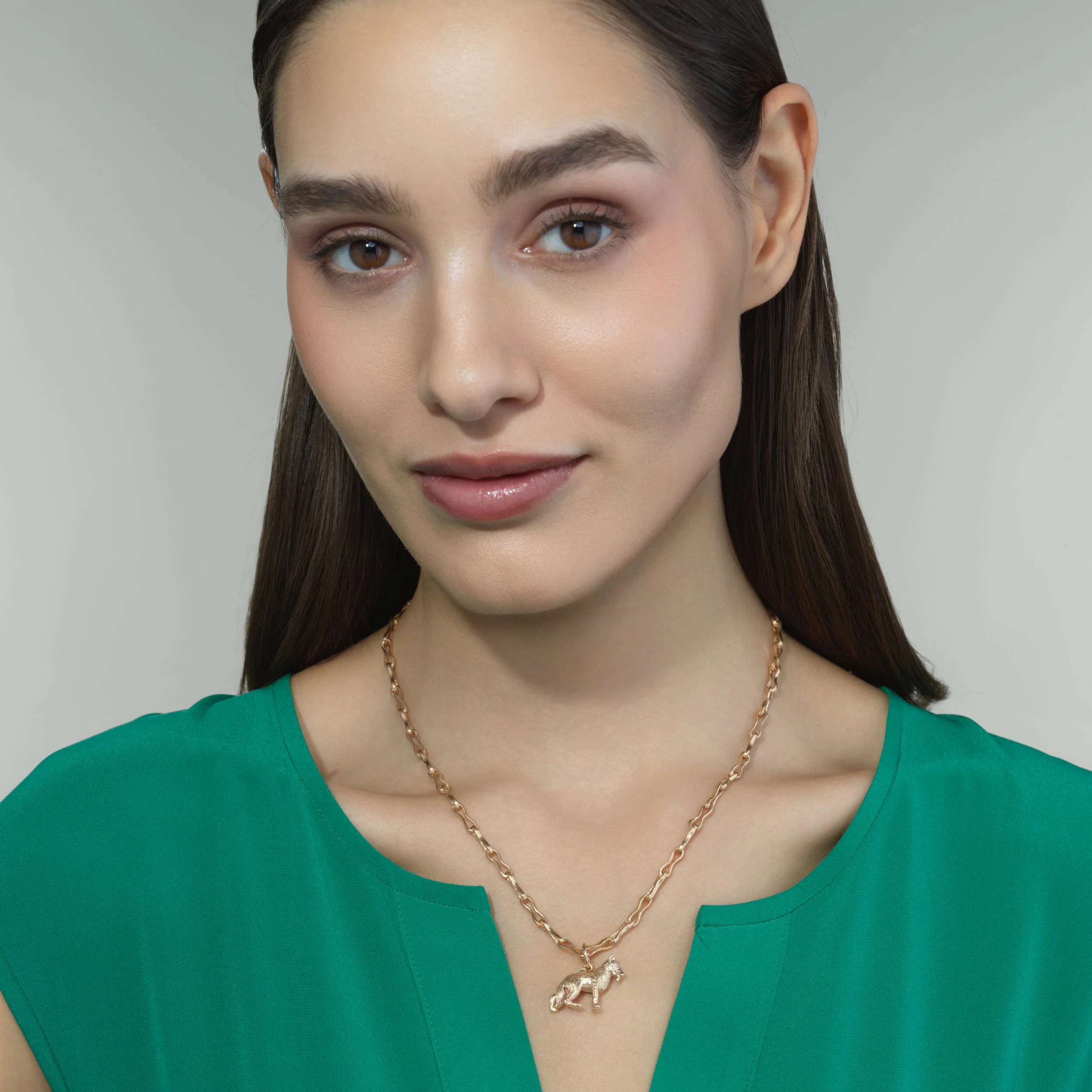 German Shepherd gold pendant shown on a model for scale