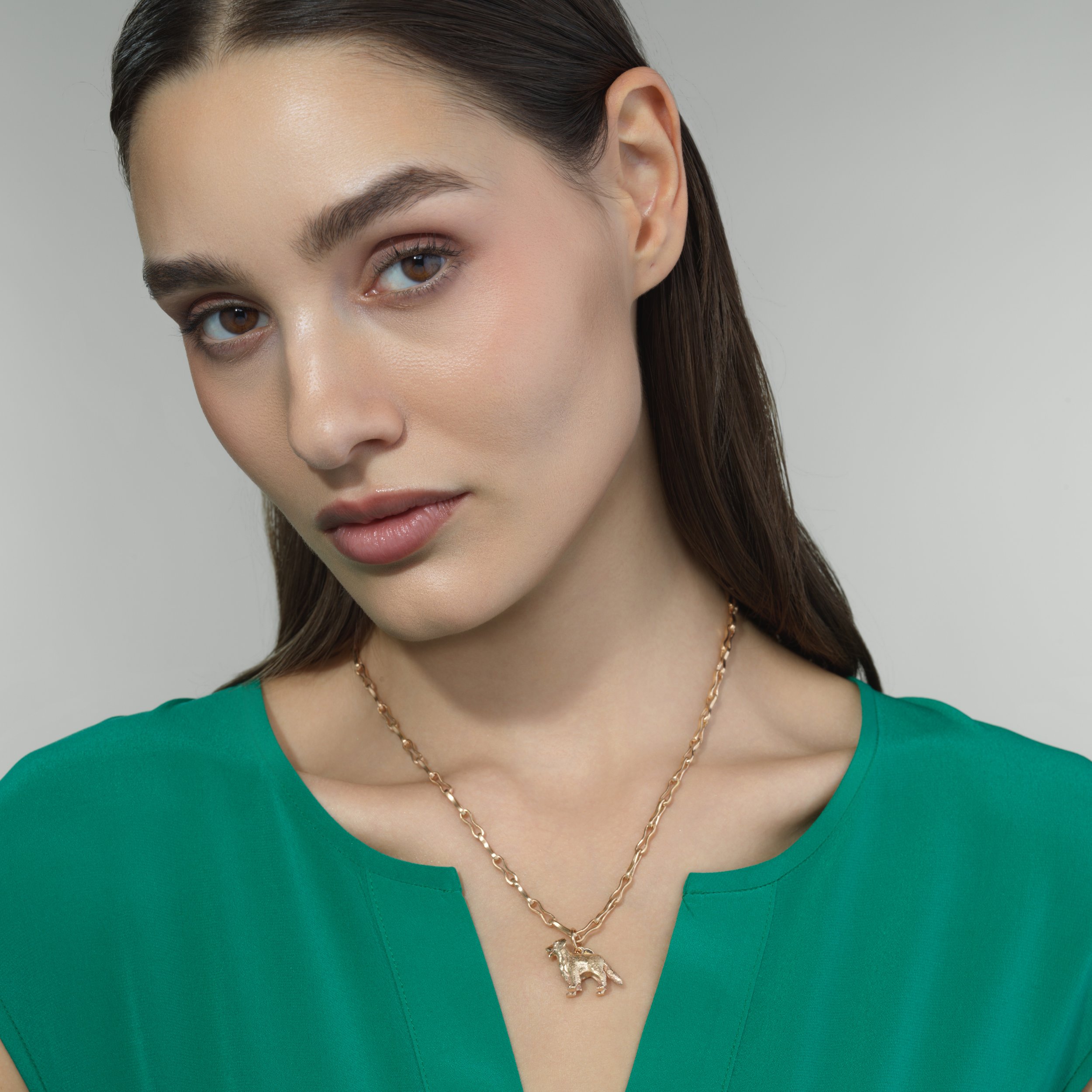 Golden Retriever gold pendant shown on a model for scale