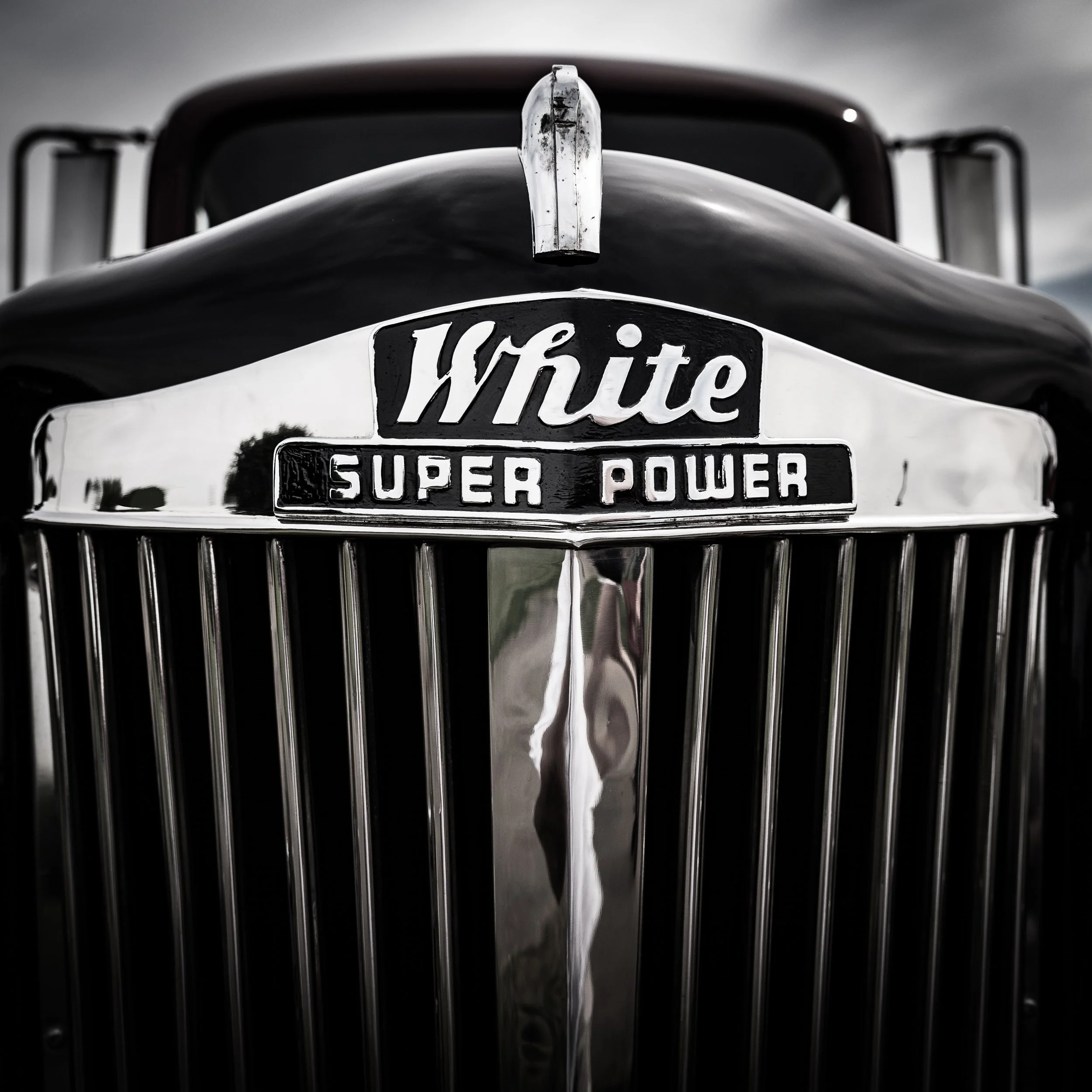 Close-up of the front grille and emblem of a vintage White Super Power truck, black and white photo.