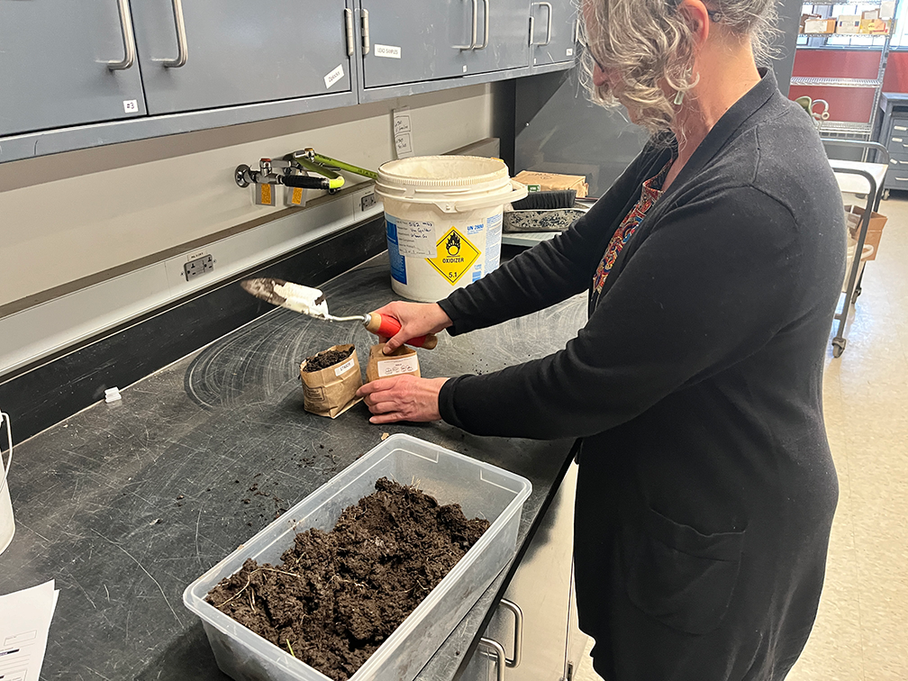 A woman helping to bag up samples of soil gathered from the future site of the Mounds Park Community Garden