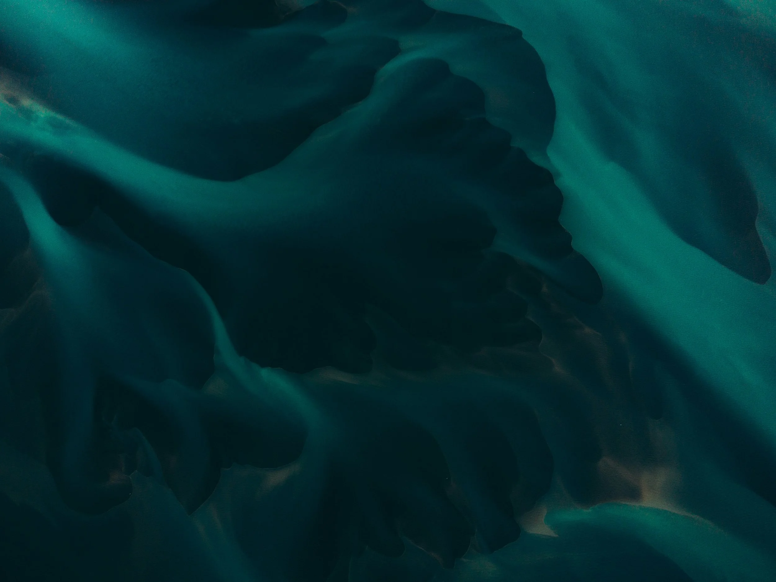 Abstract swirling patterns in shades of dark teal, green, and black.