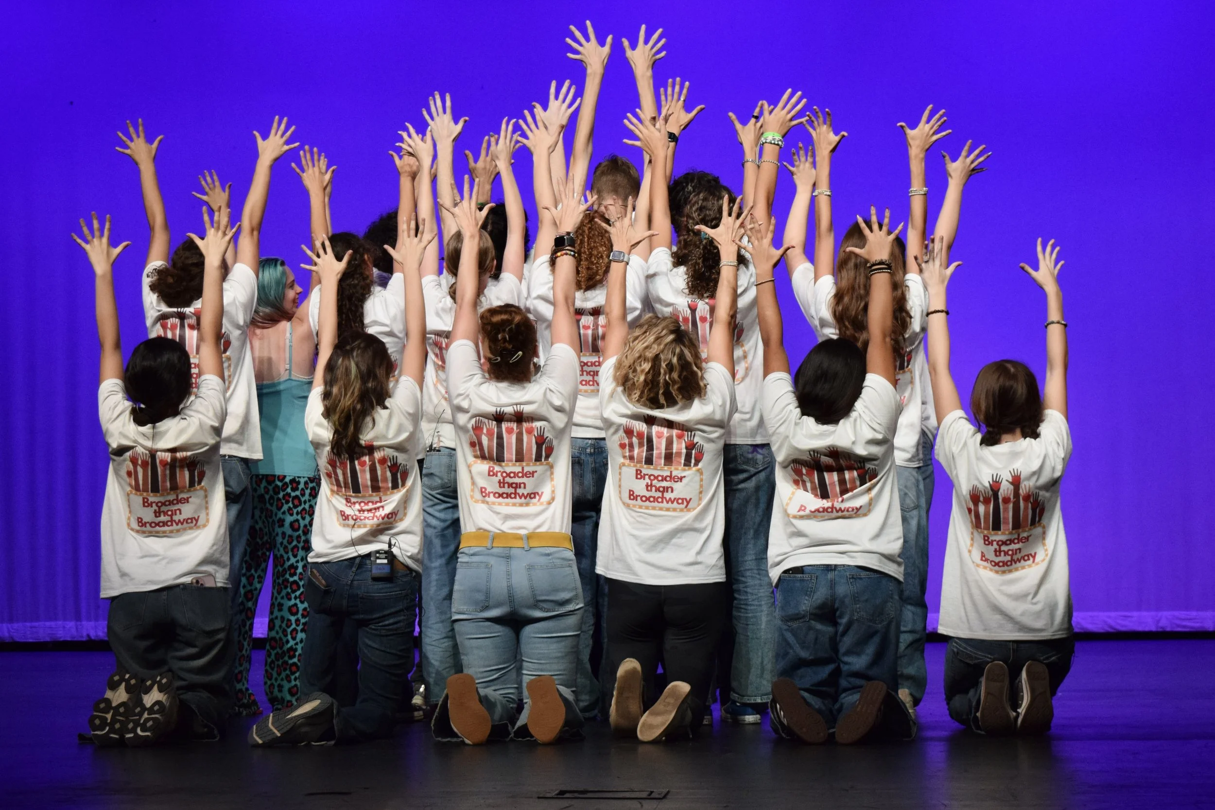 Various raised hands with red hearts on palms, adorned with colorful rings, bracelets, and jewelry, symbolizing love and unity.