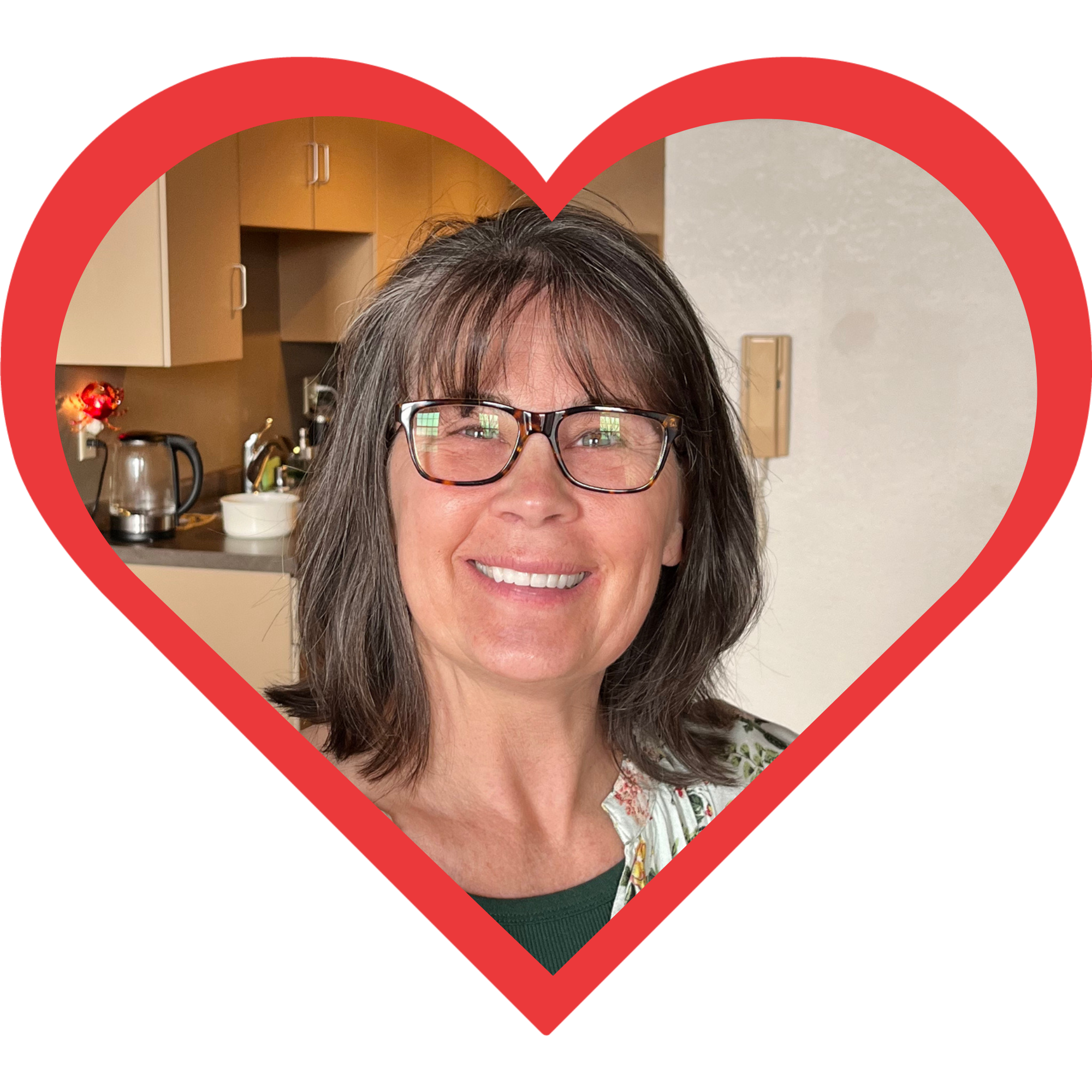 A woman with glasses smiling inside a heart-shaped frame.
