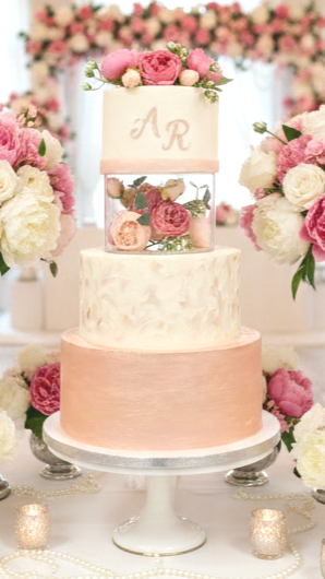 A sophisticated three-tier masterpiece designed for an elegant celebration of 70 guests. This design features a unique, clear acrylic spacer filled with fresh peonies, creating a stunning "floating" top tier.
A blend of textured ivory frosting, a lus