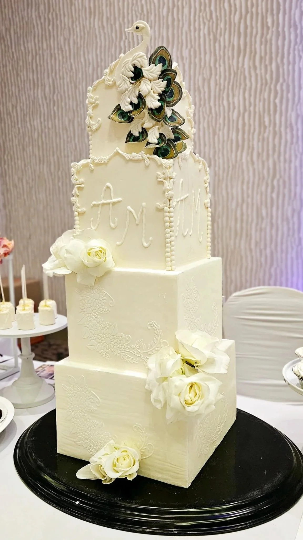Grand 4-tier luxury wedding cake for 300 guests, inspired by Indian palaces & elegant peacocks. Features intricate sugar details, hand-piped florals, and a sculptural topper. A majestic centrepiece for celebrations of love & abundance from Magnolia C