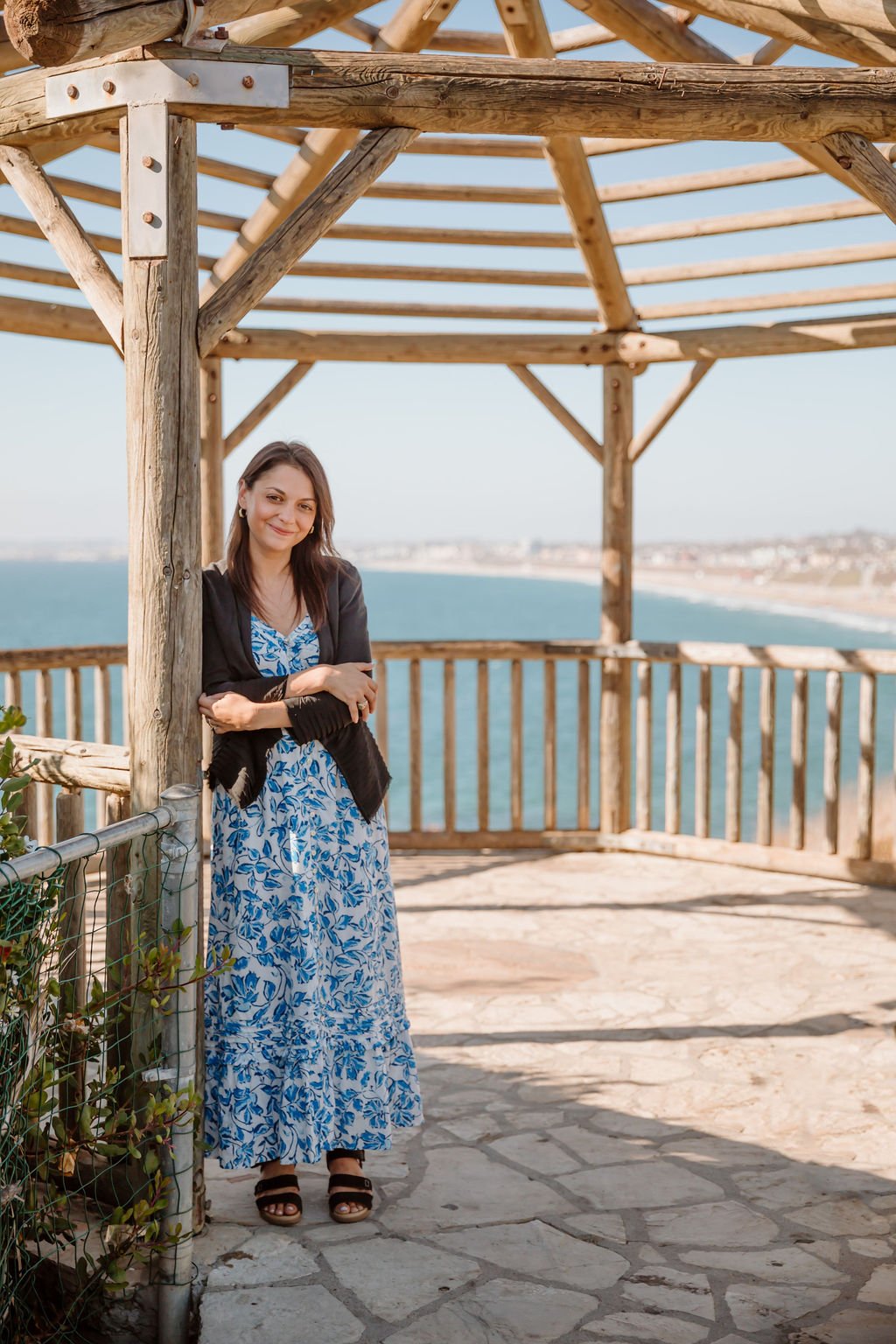 Morgan Abraham, LCSW, smiling on a wooden deck overlooking the ocean