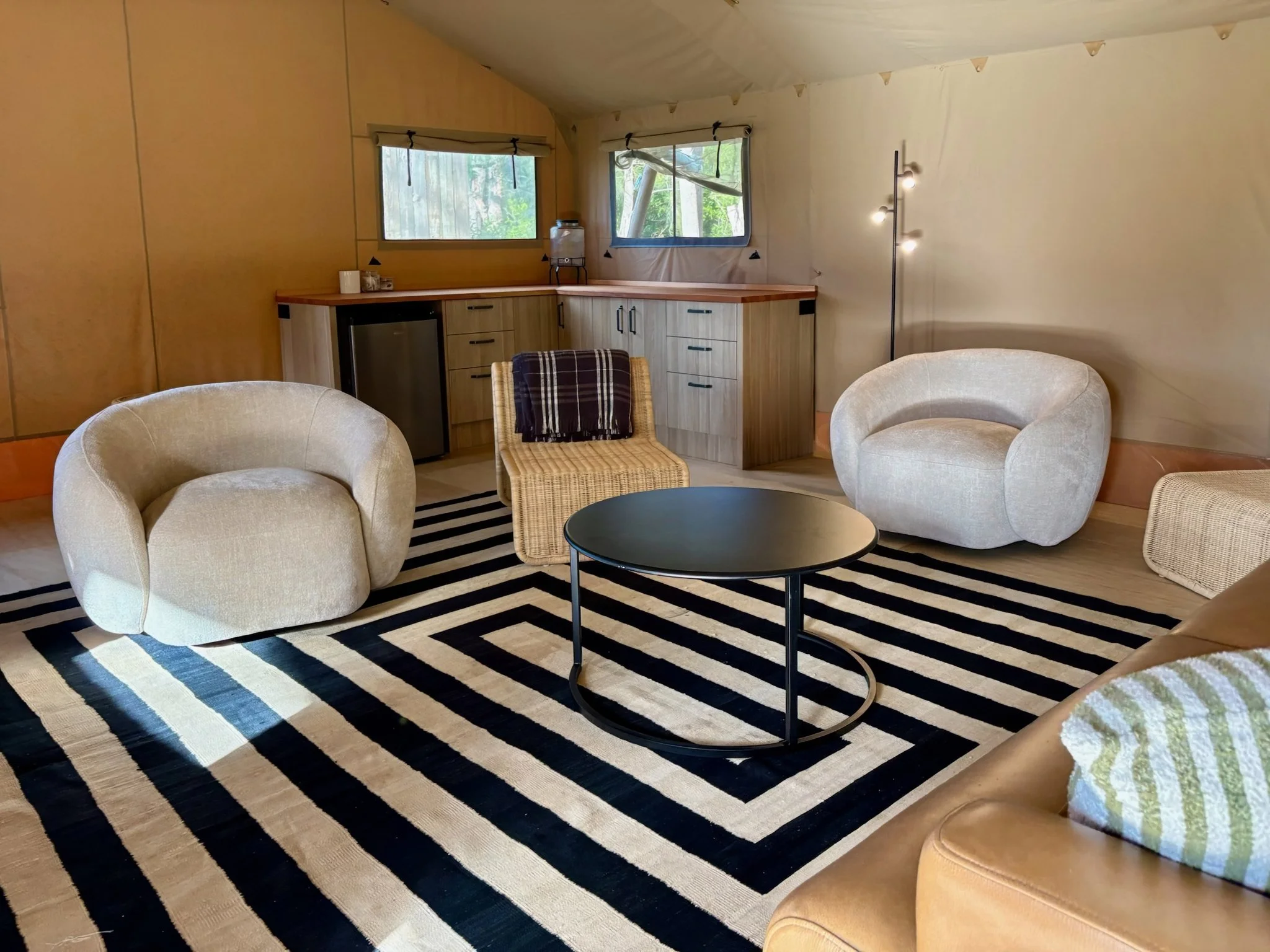 Safari tent living area with lounge seating, Black Swamp glamping lodge Mangawhai