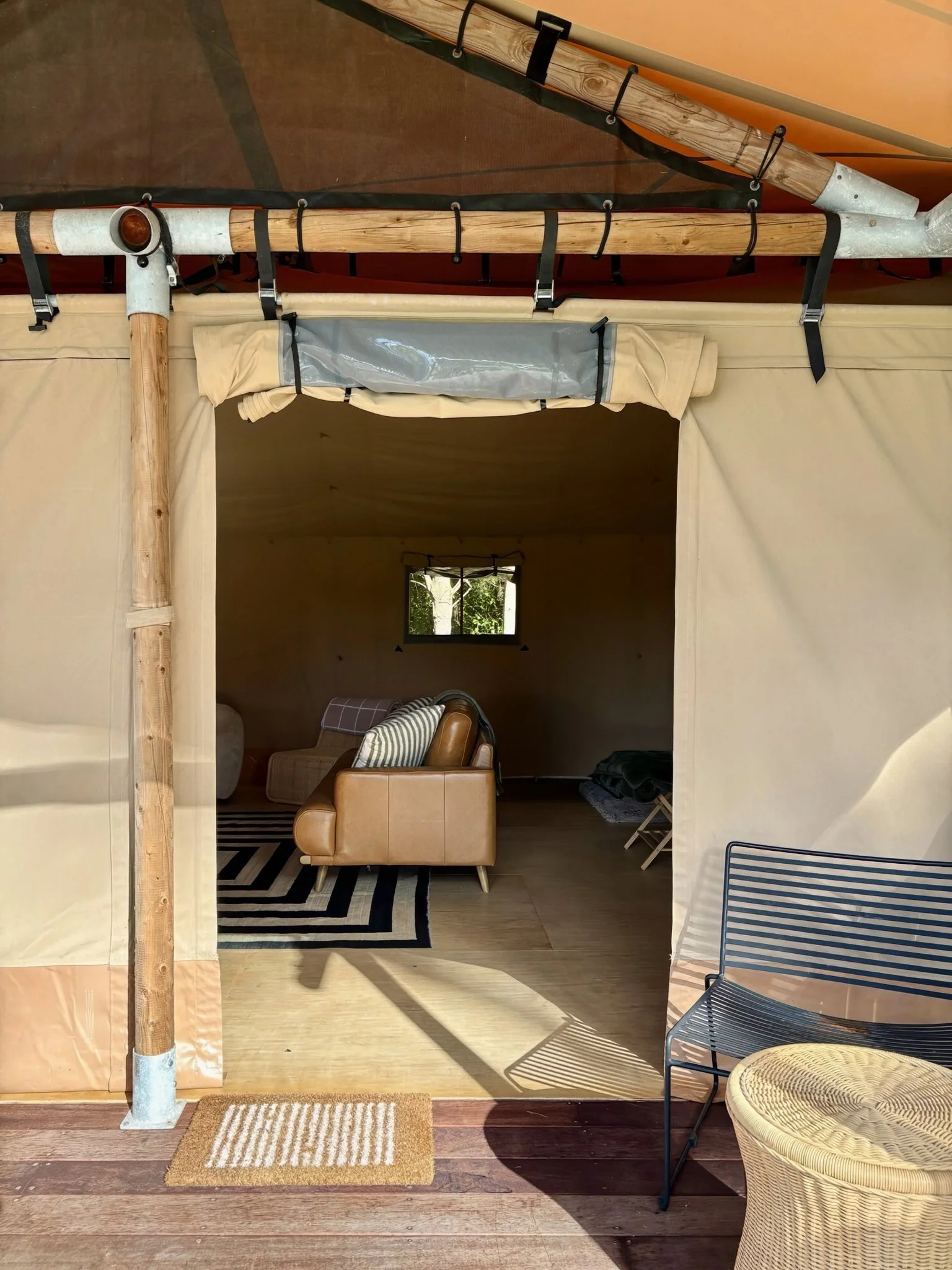 Safari tent entrance with timber sliding door, Black Swamp glamping lodge Mangawhai