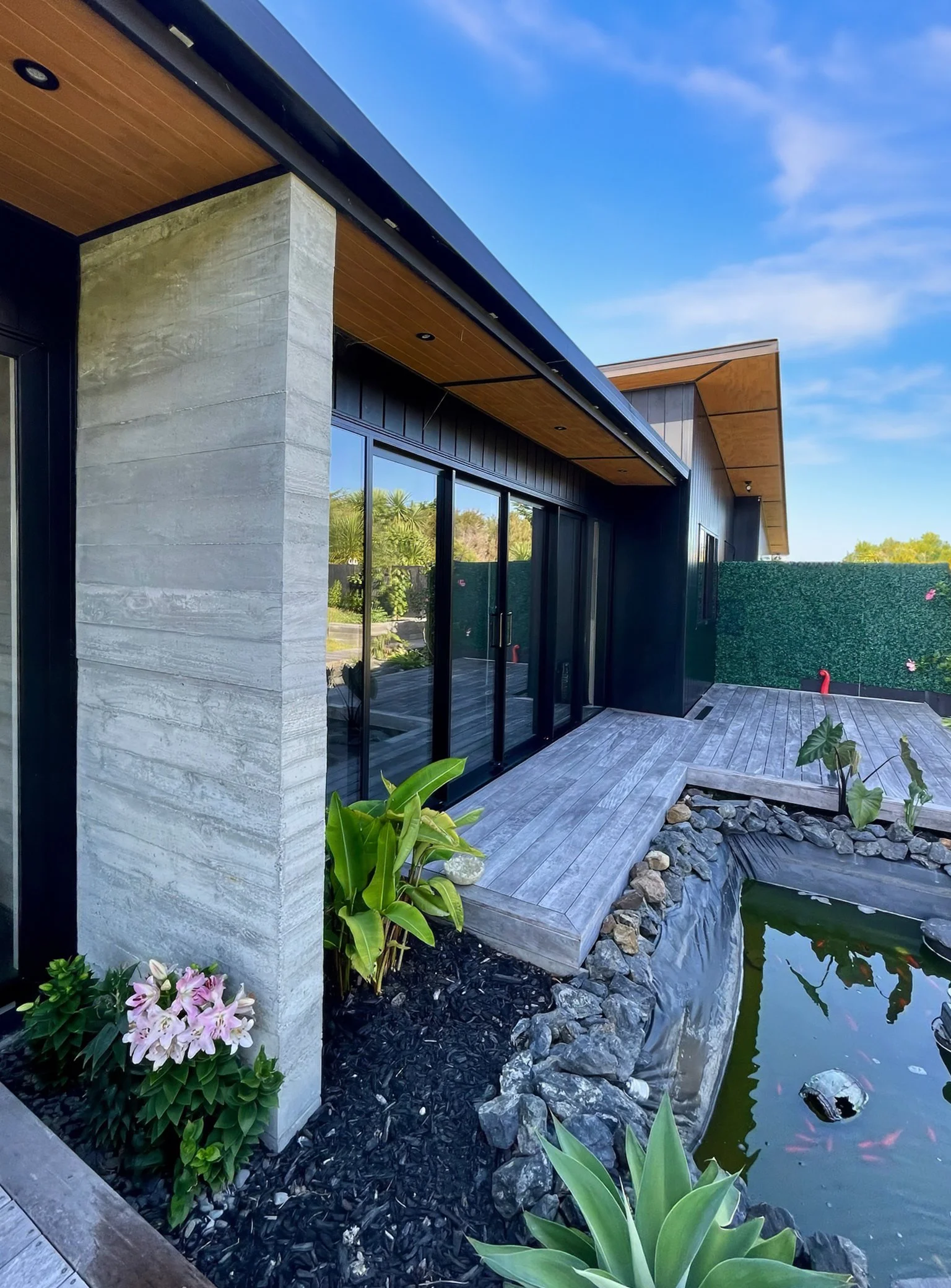 Sanctuary Ridgeview luxury new home with dark cladding and koi pond, Mangawhai