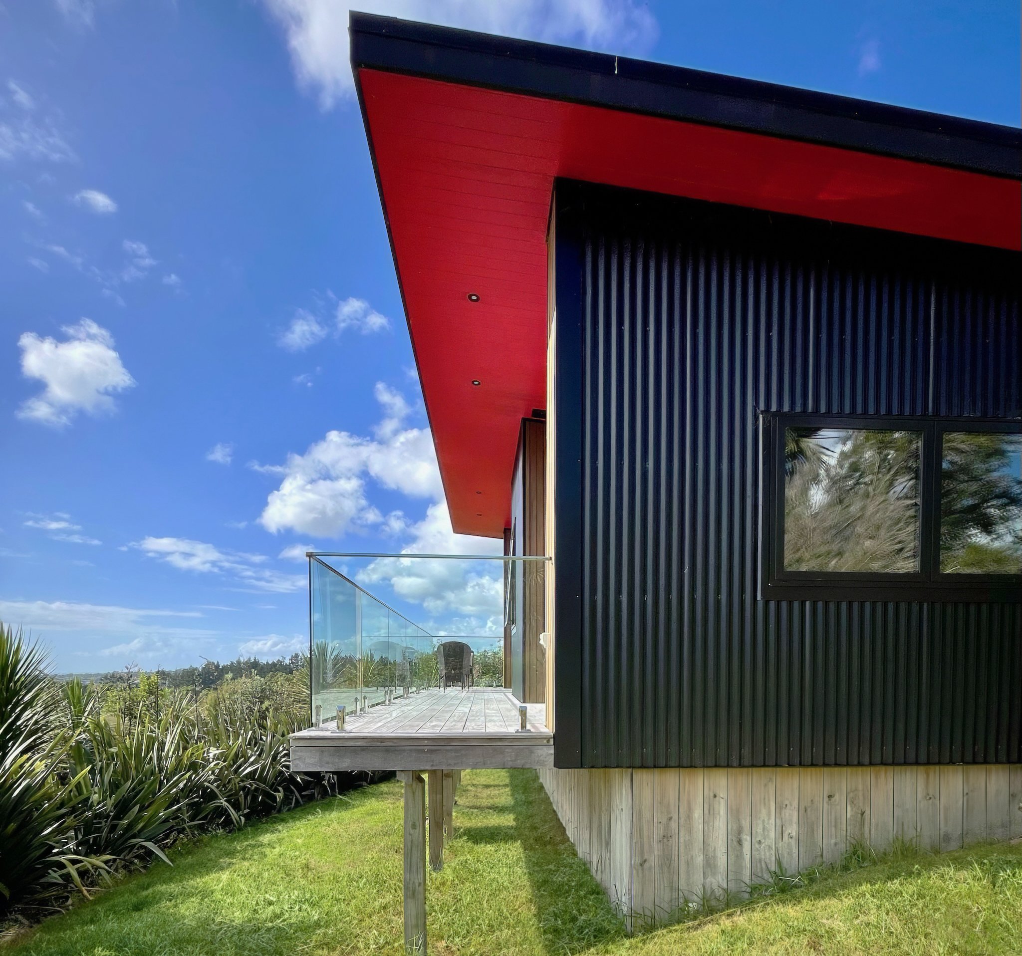 Sanctuary Ridgeview new build guest house exterior view with dark cladding and decking, Mangawhai