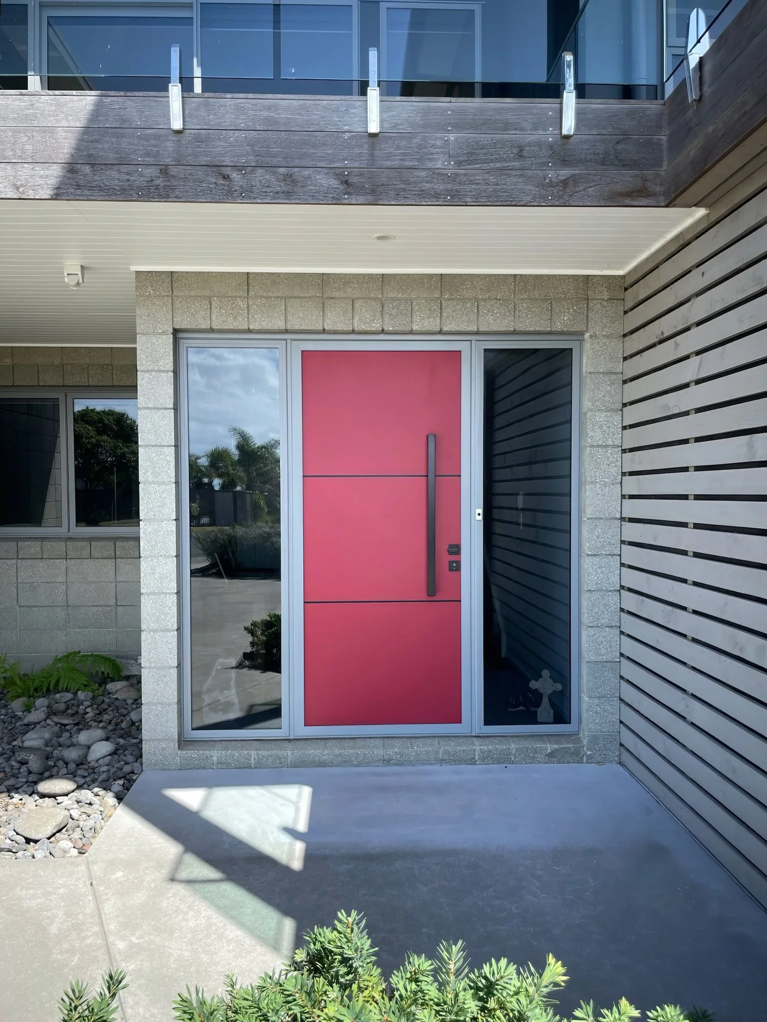 Driftwood new home entry with bold red door and cladding detail, Elite Building Northland
