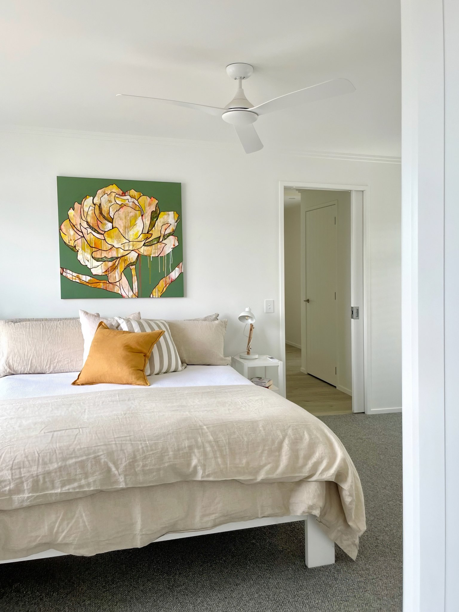 Swordfish luxury master bedroom with original artwork and warm tones, Mangawhai