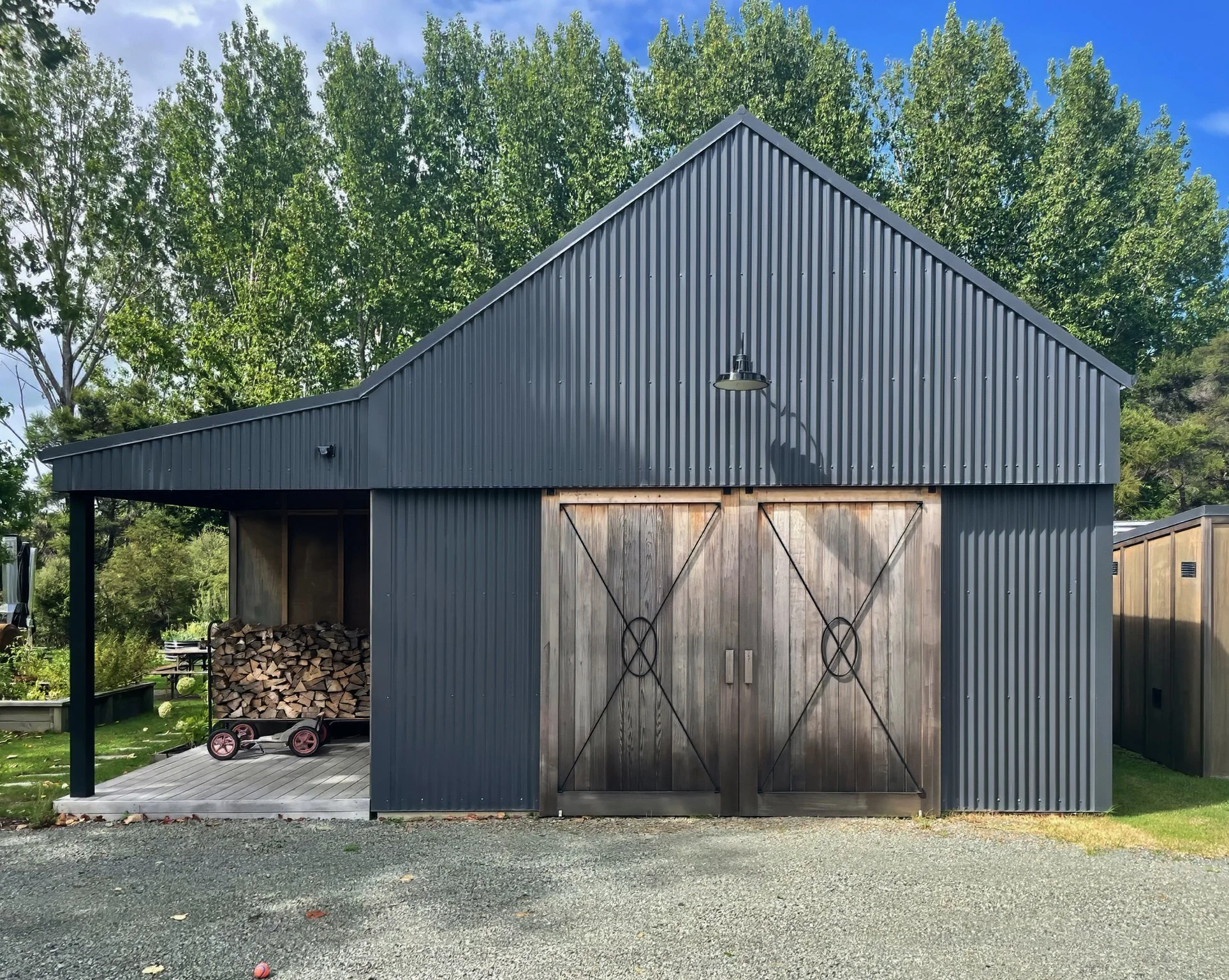 Dark board and batten garage with timber doors, Waiotahi Drive new home build Elite Building Northland