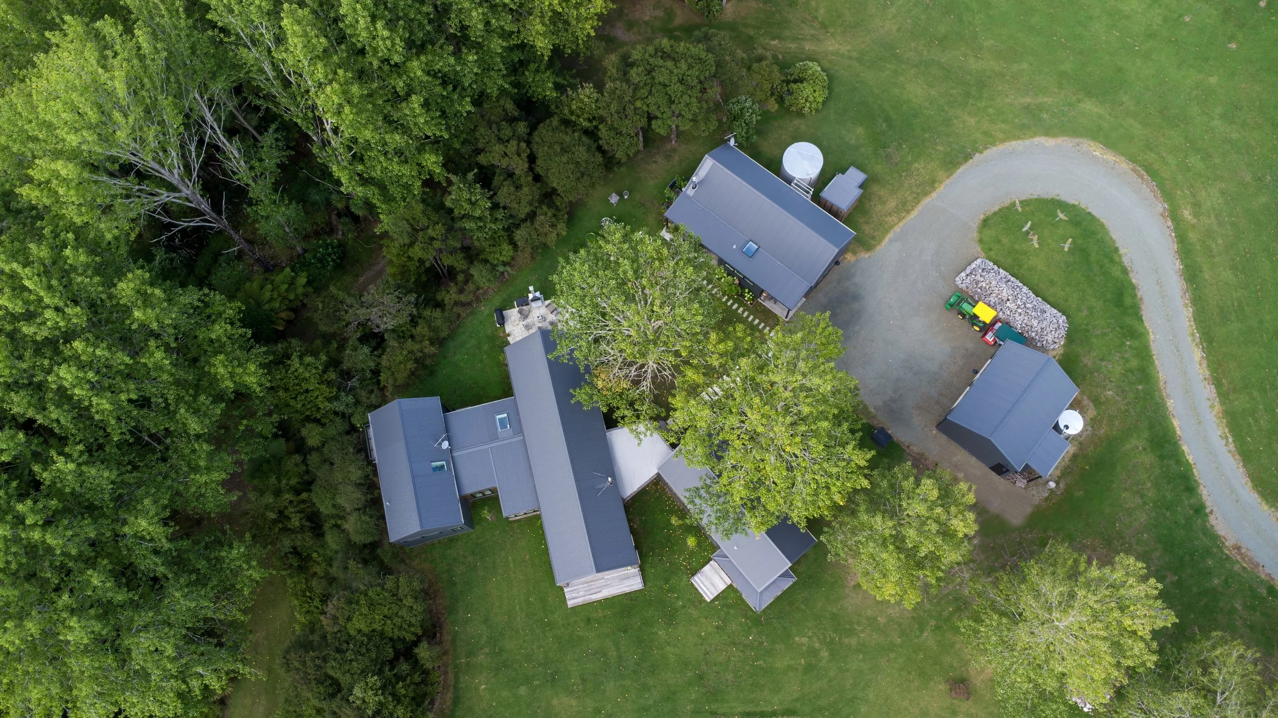 Drone aerial view of Waiotahi Drive new home build surrounded by established trees, Elite Building Mangawhai