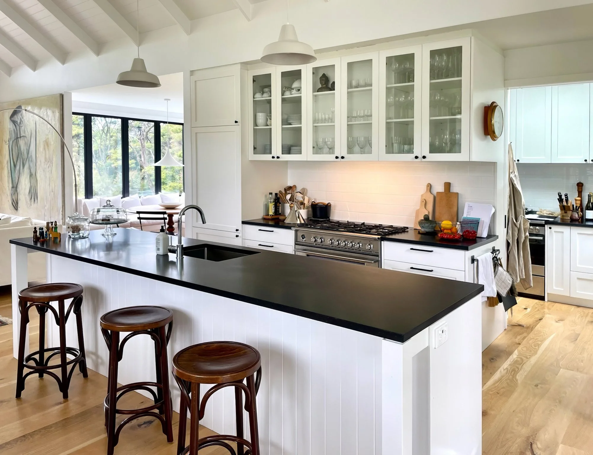 Luxury white kitchen with black benchtop and bar stools, Waiotahi Drive new home Elite Building Mangawhai