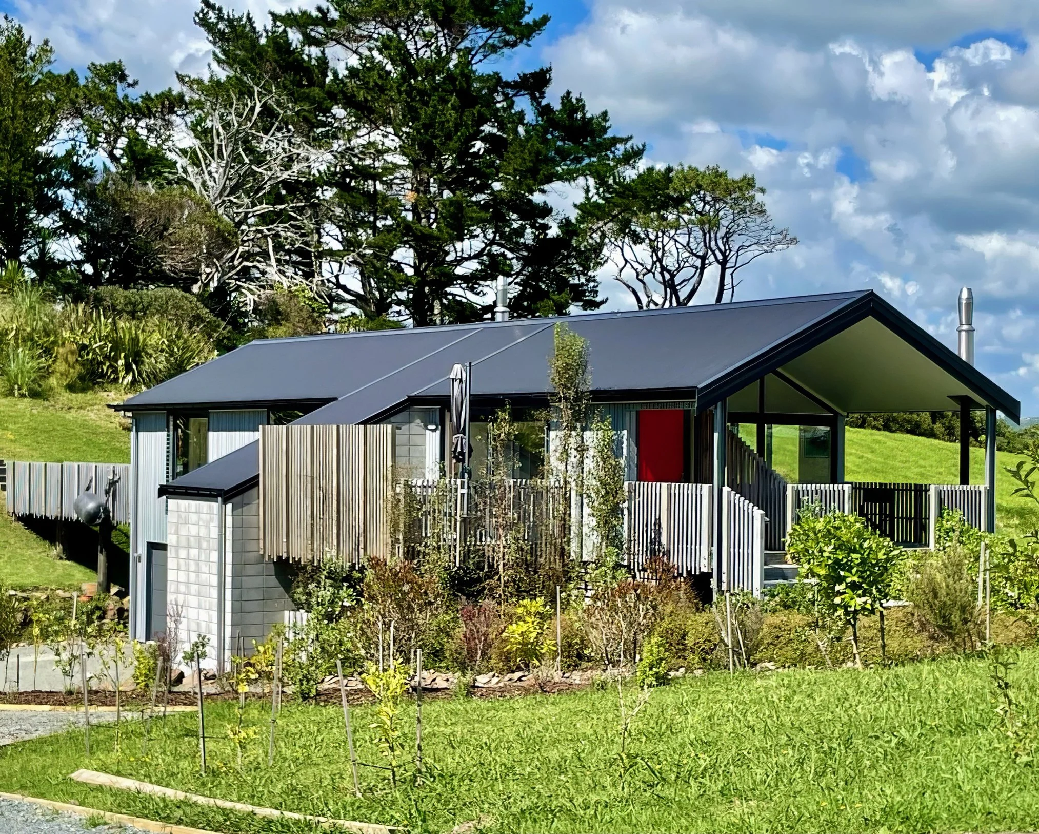 Mangawhai Point new home full exterior with dark cladding and coastal surroundings, Elite Building Mangawhai