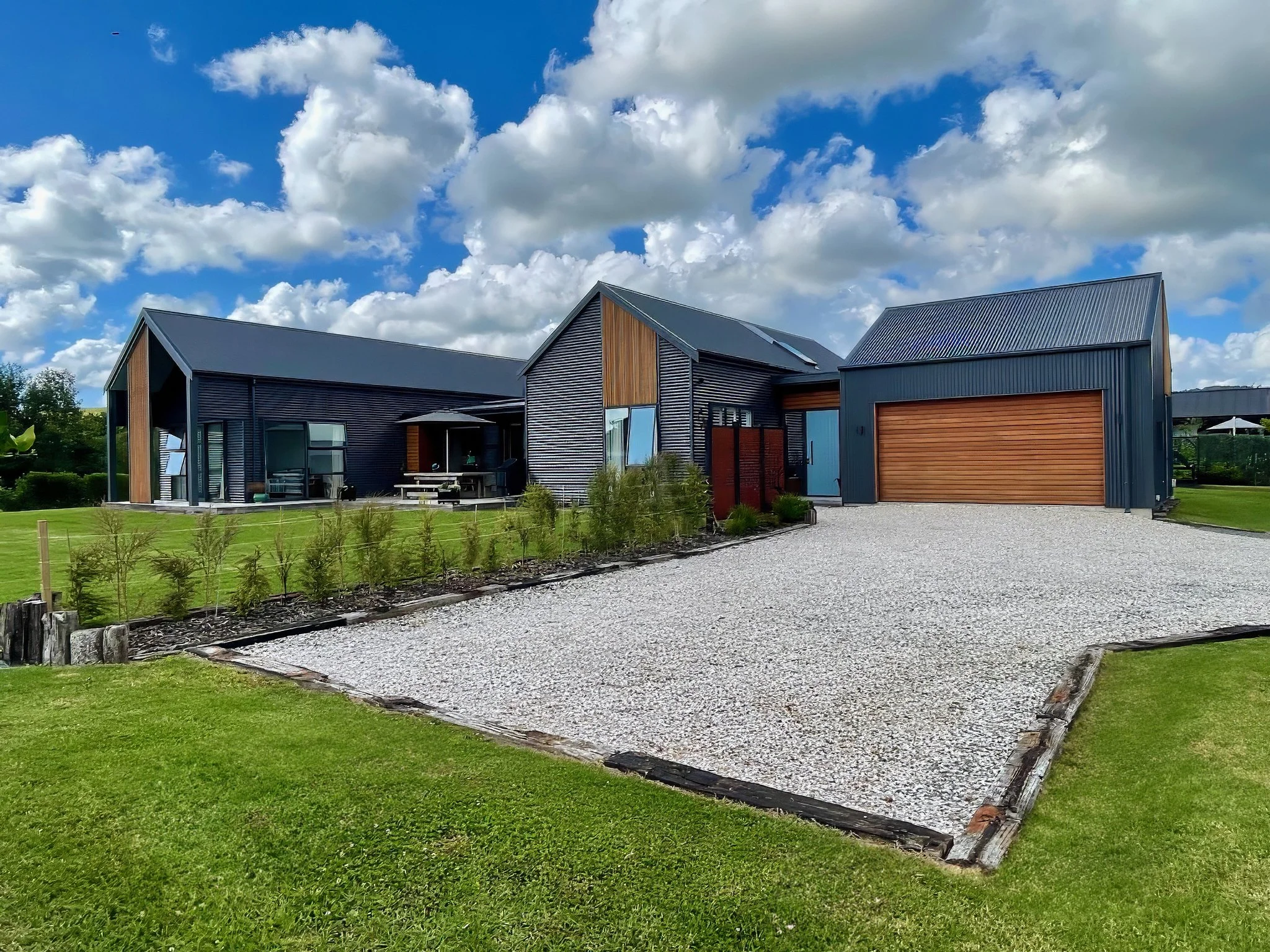 Alexandra Lane new home with exposed aggregate driveway and timber garage door, Elite Building Mangawhai