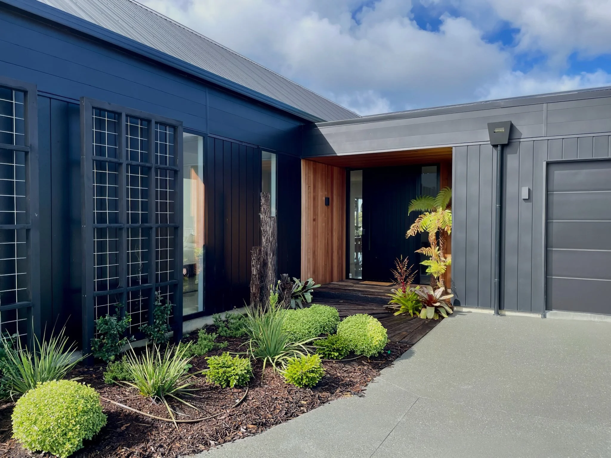 Sand Dune luxury new home entry with louvre screening and tropical gardens, Northland
