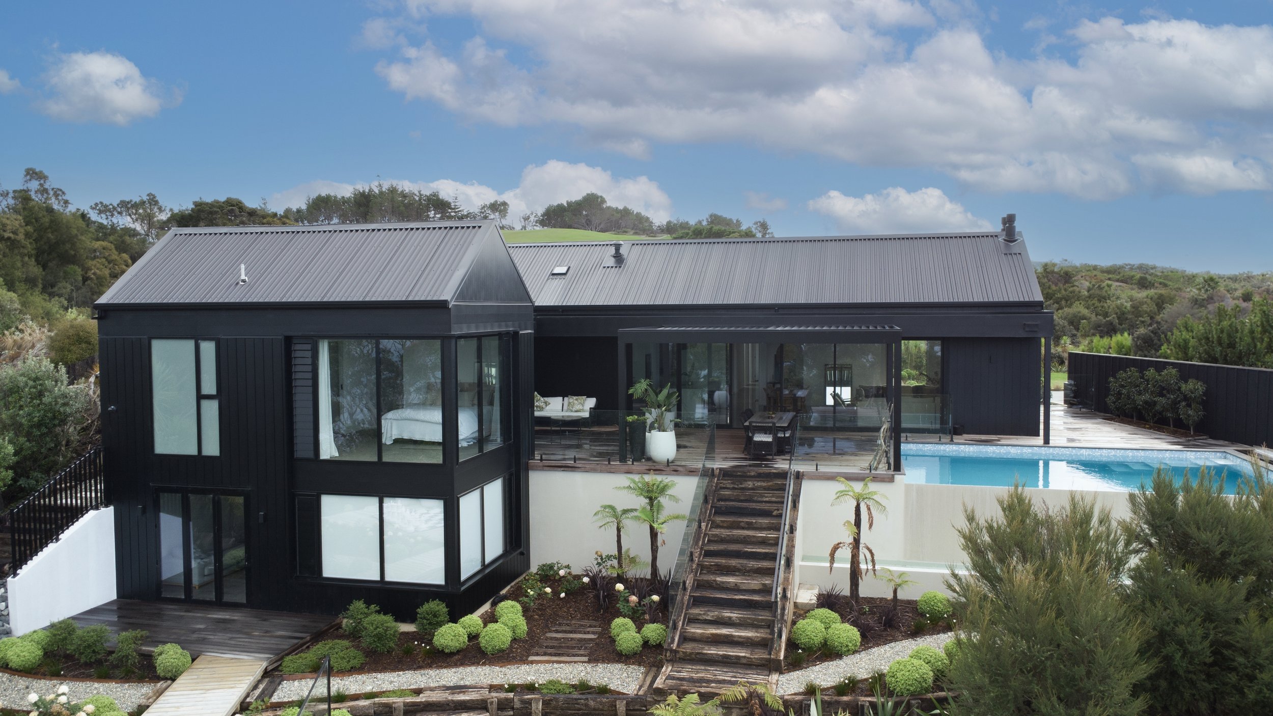 Sand Dune new home build with dark cladding and landscaped steps, Mangawhai